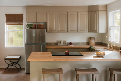 A modern kitchen with light wood countertops and island.