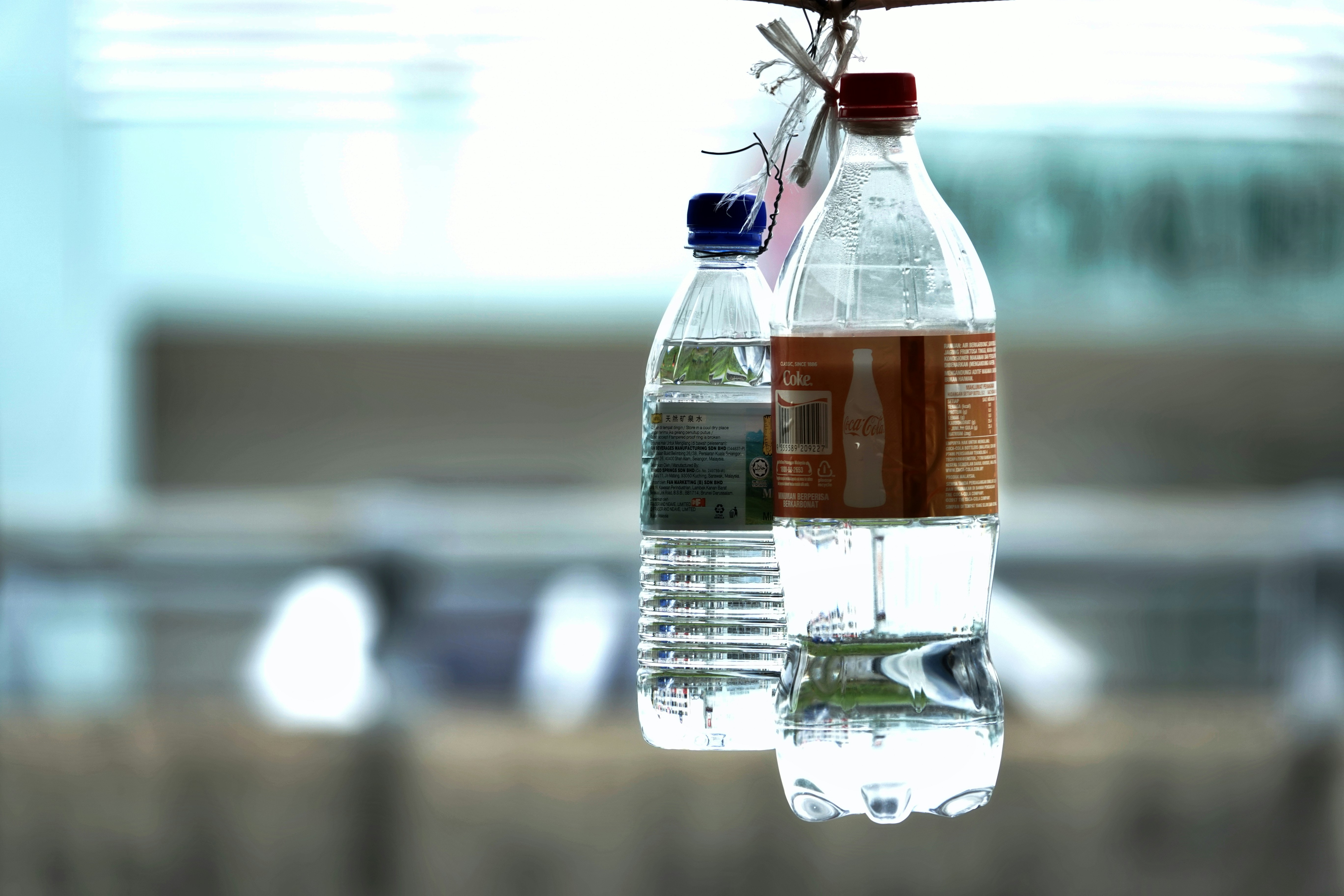 Two plastic water bottles hanging outdoors