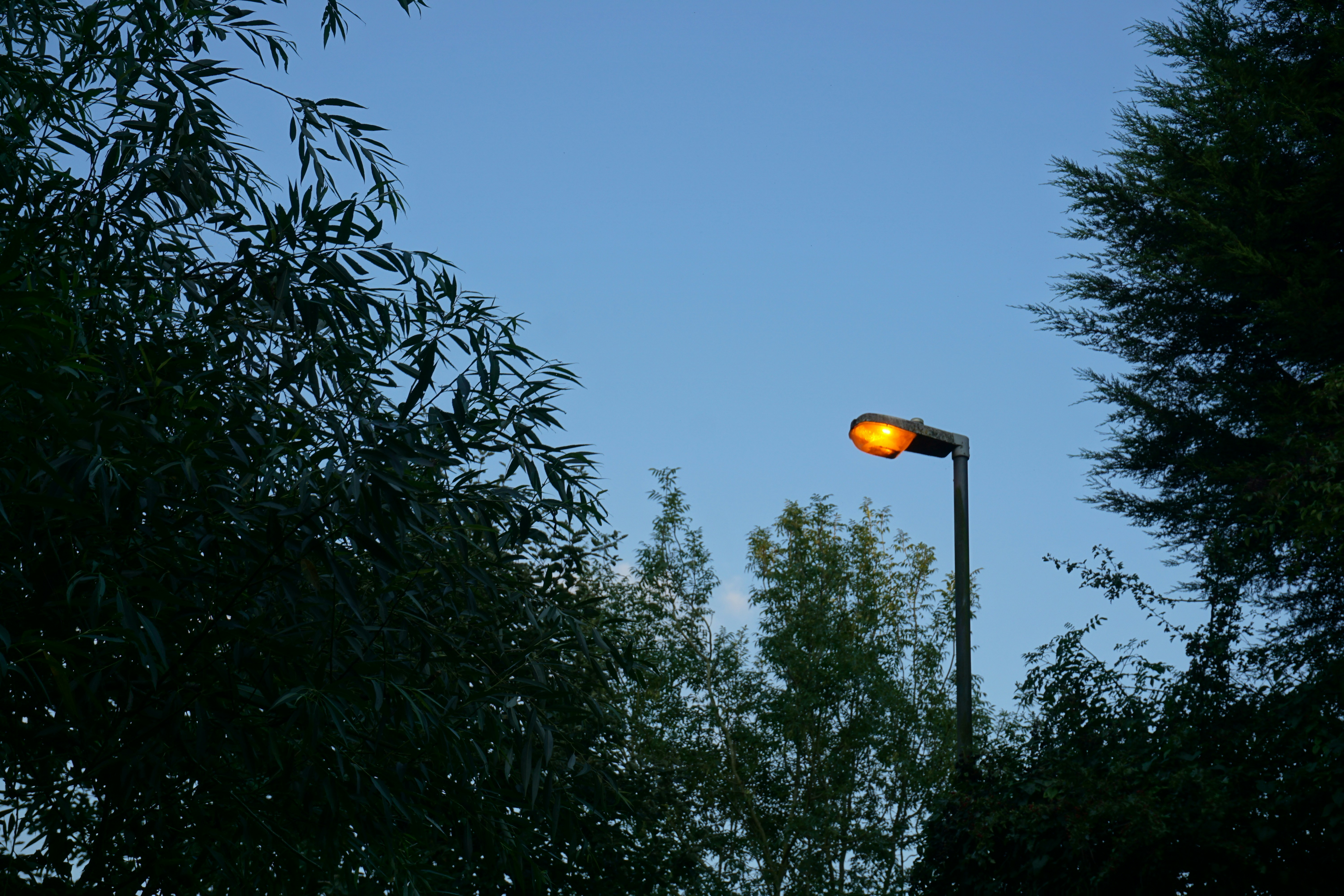 Il lampione brilla contro un cielo azzurro e limpido.