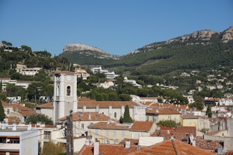 Town with church steeple below forested mountains