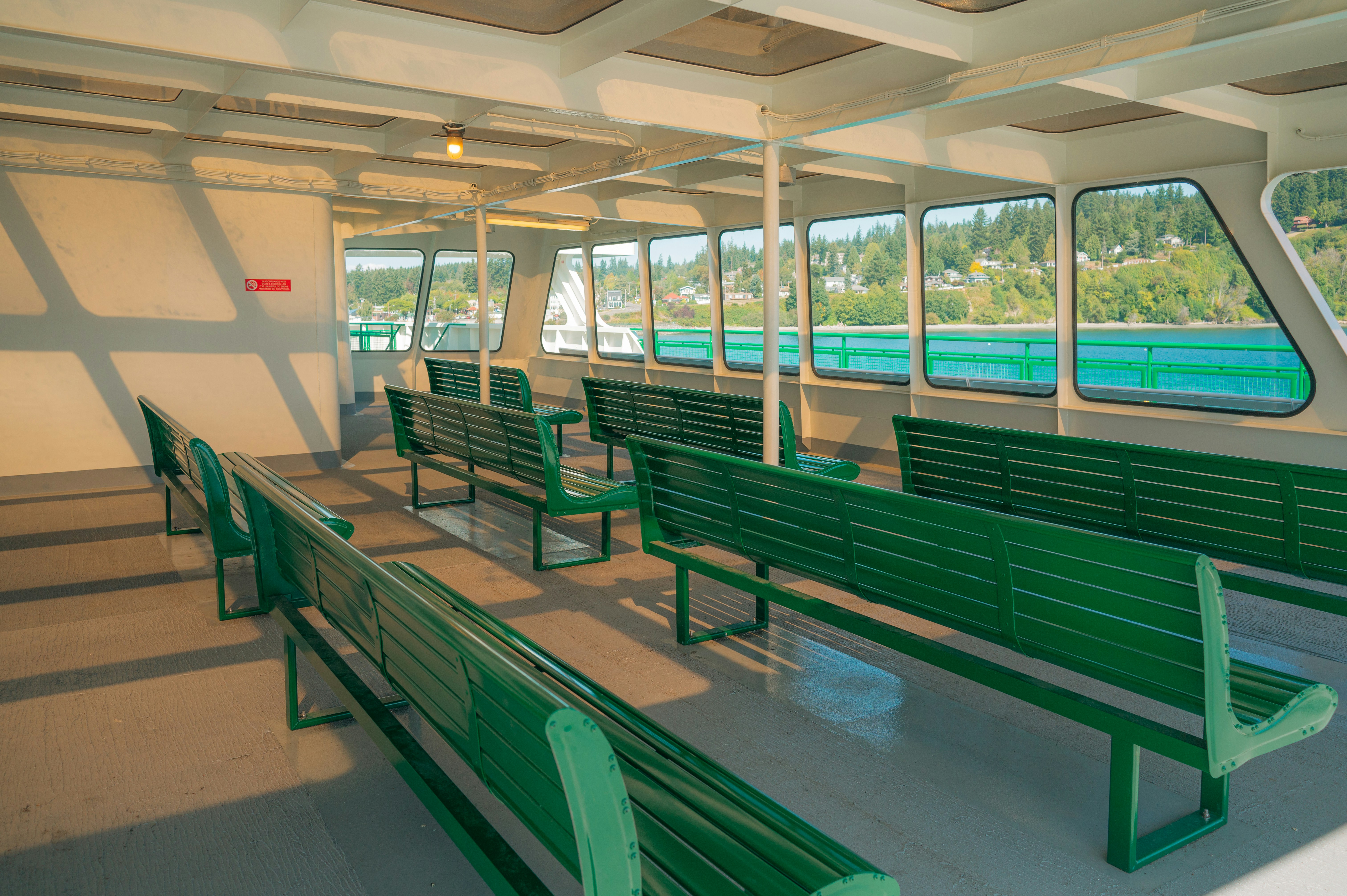 Empty green benches on a ferry with water view