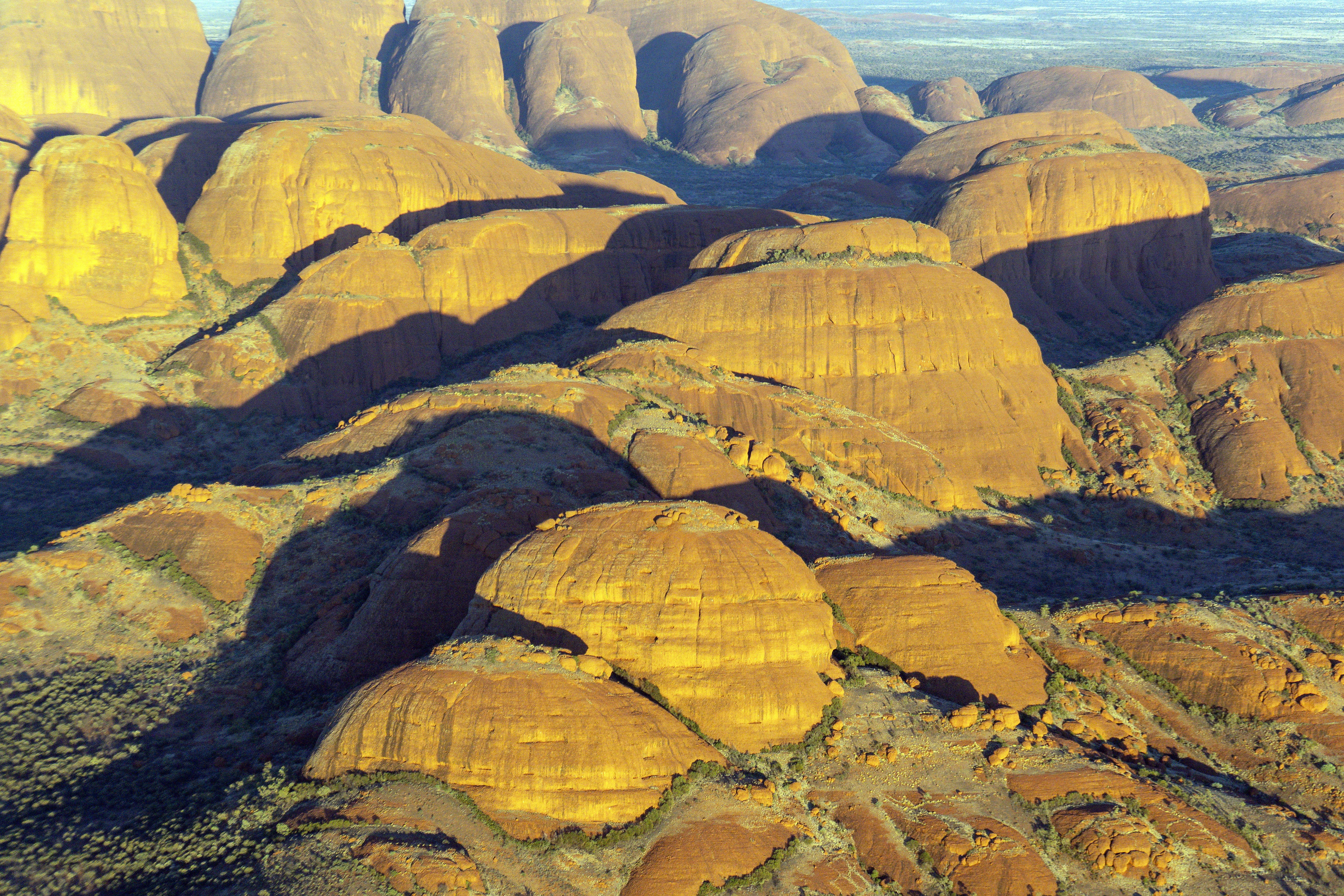 Golden rock formations casting long shadows at sunset.