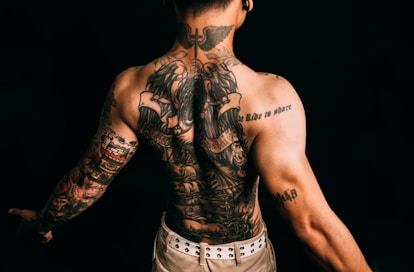Man with elaborate full back and arm tattoos