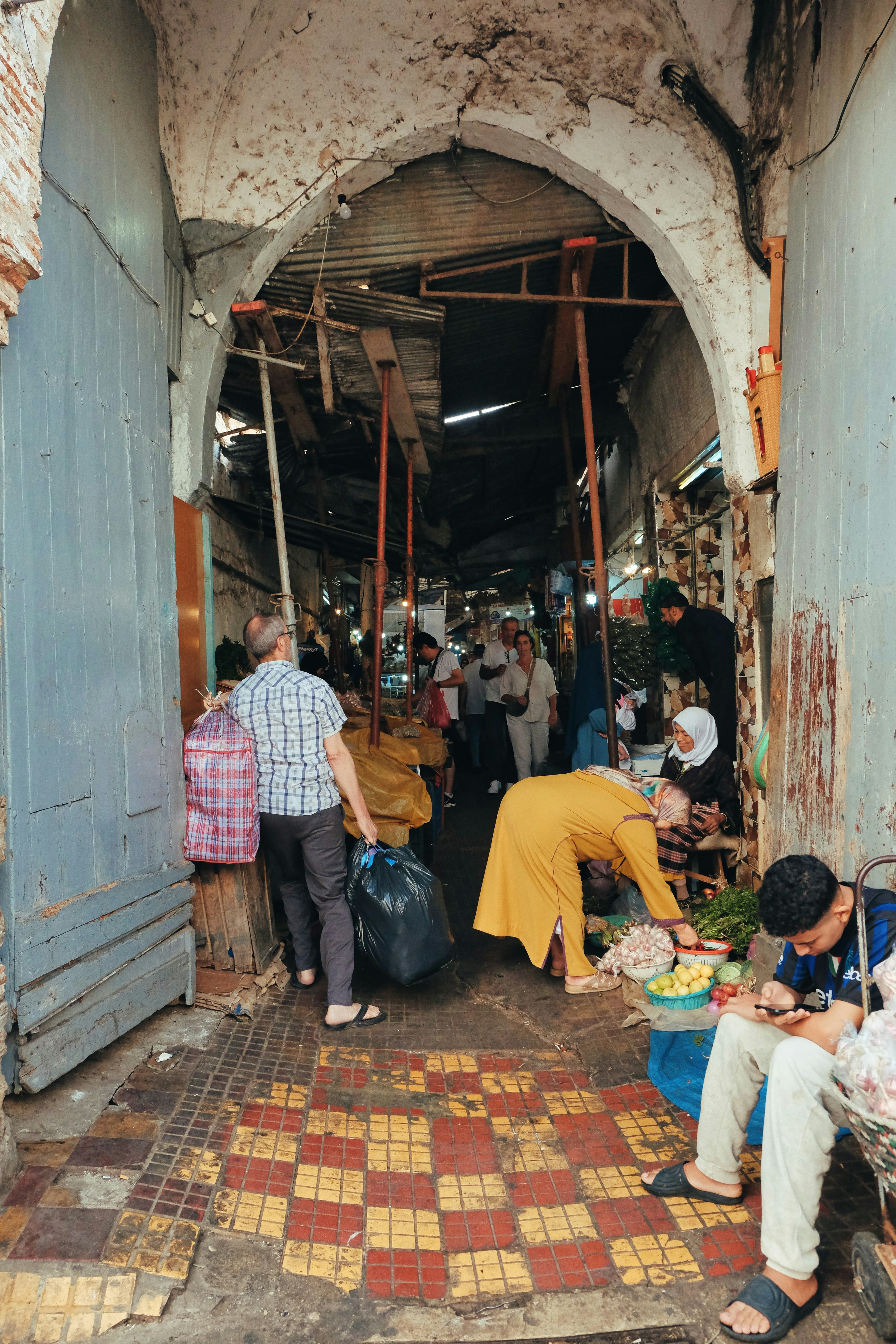 People shopping in a bustling moroccan market alley.
