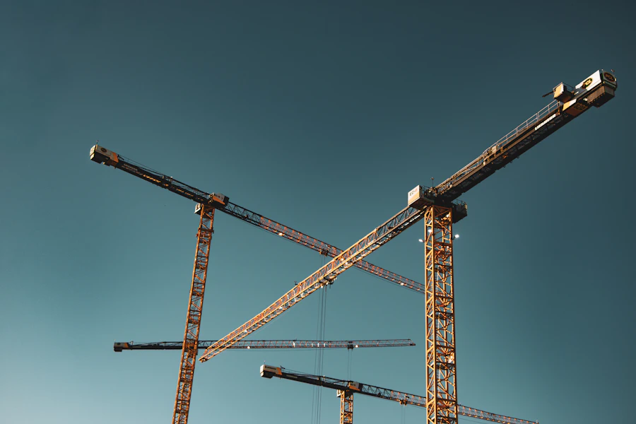 Construction cranes against a clear sky