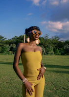 Woman in yellow jumpsuit with heart sunglasses outdoors