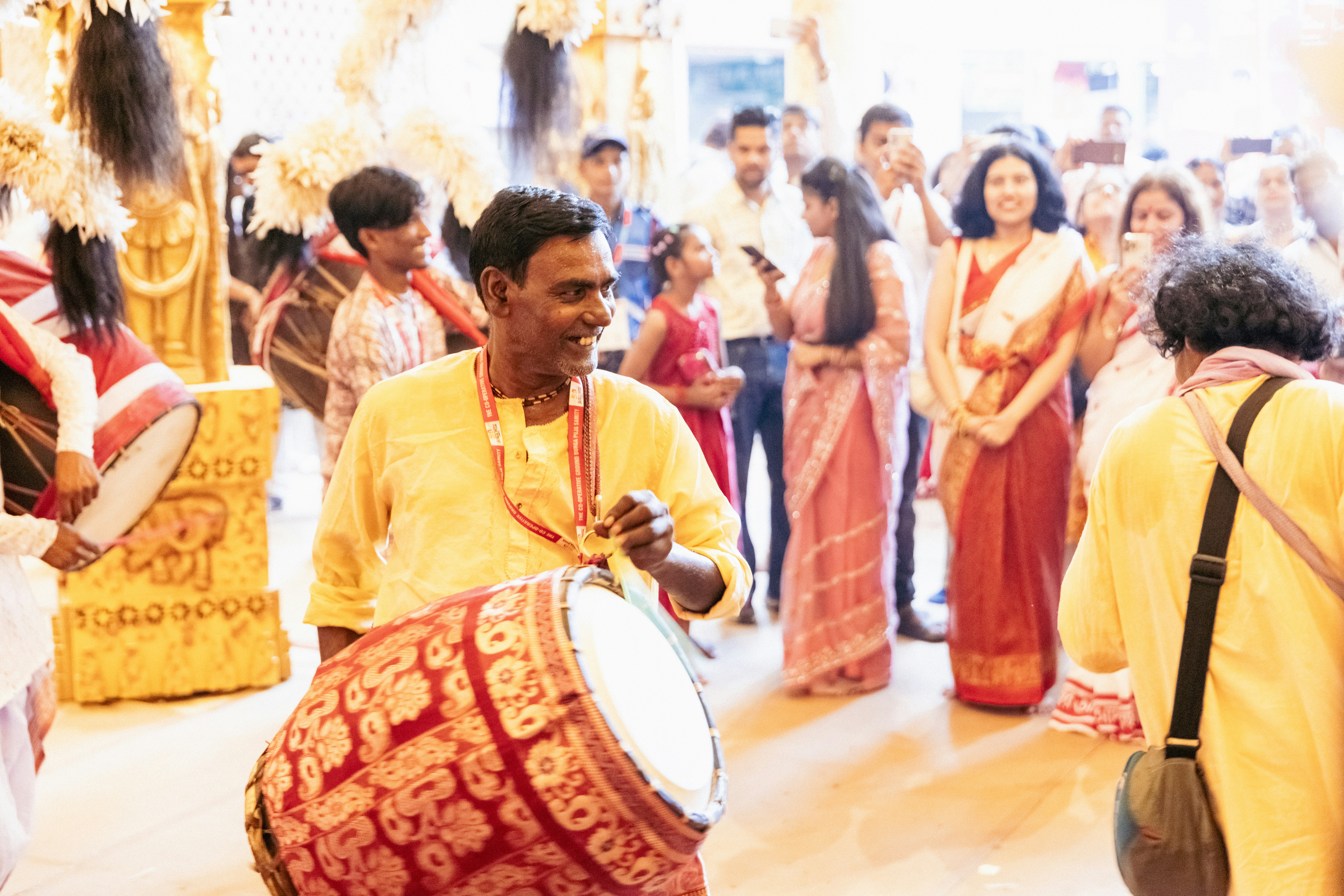 Man plays a drum in a festive crowd
