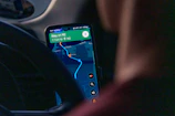 Person using navigation app on smartphone inside car.