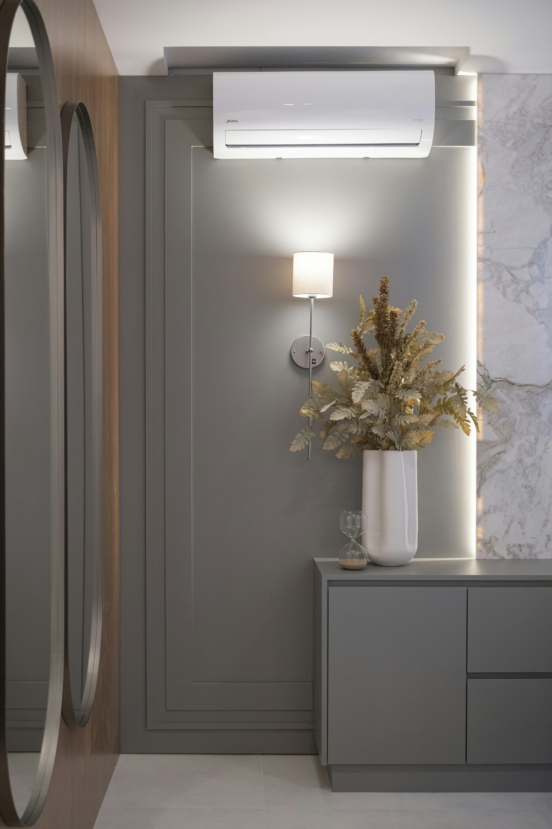 Modern entryway with mirrors and dried floral arrangement.