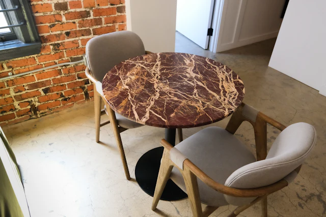 Round red marble table with two upholstered chairs