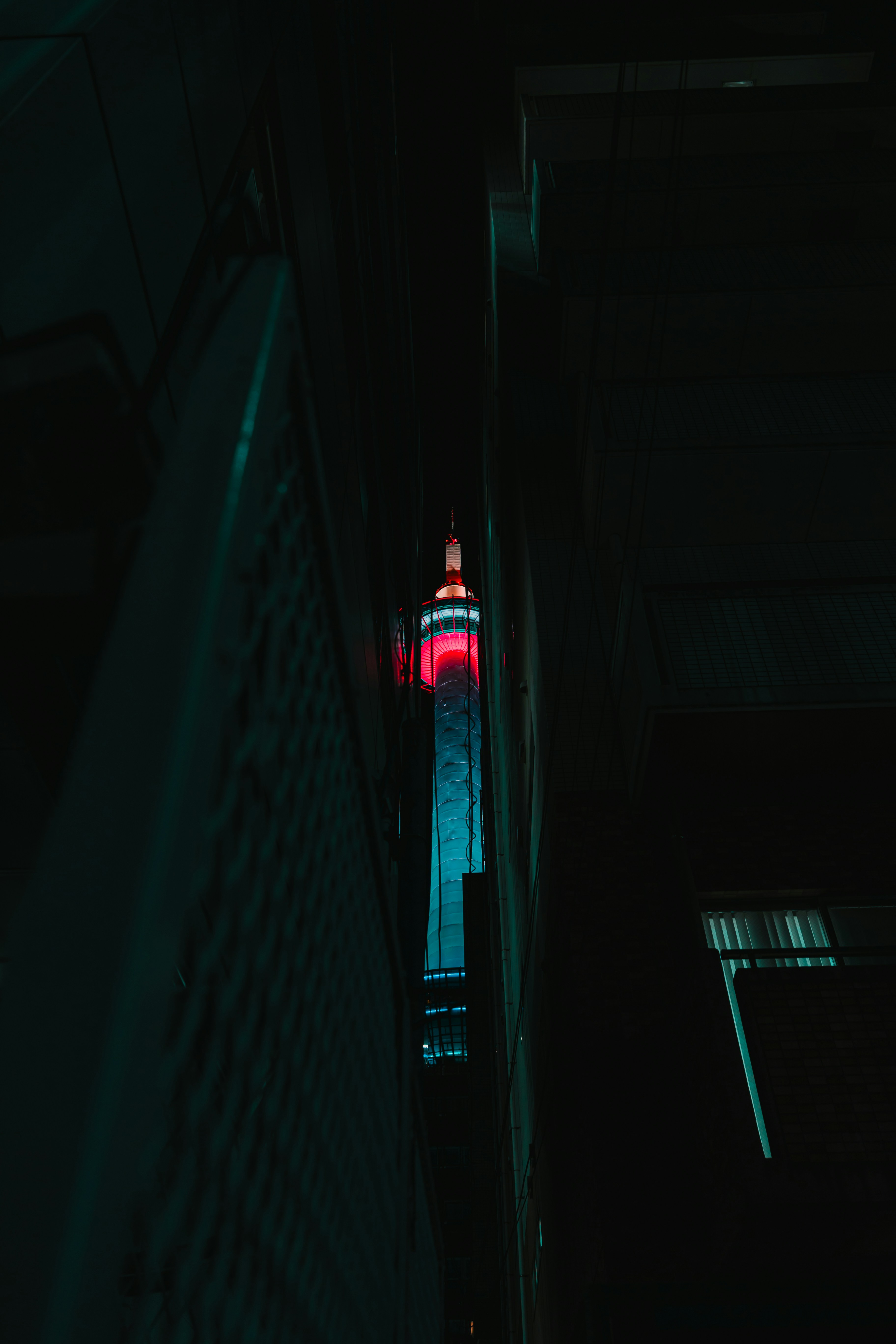 Illuminated skyscraper with red lights at night