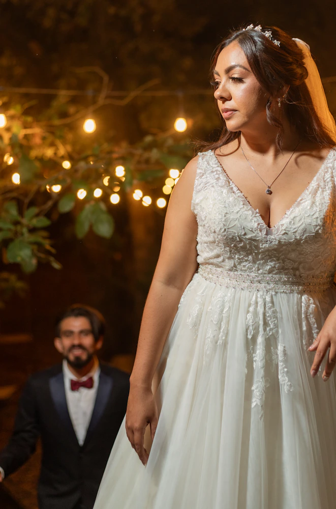 Outdoor wedding reception lit by warm fairy lights