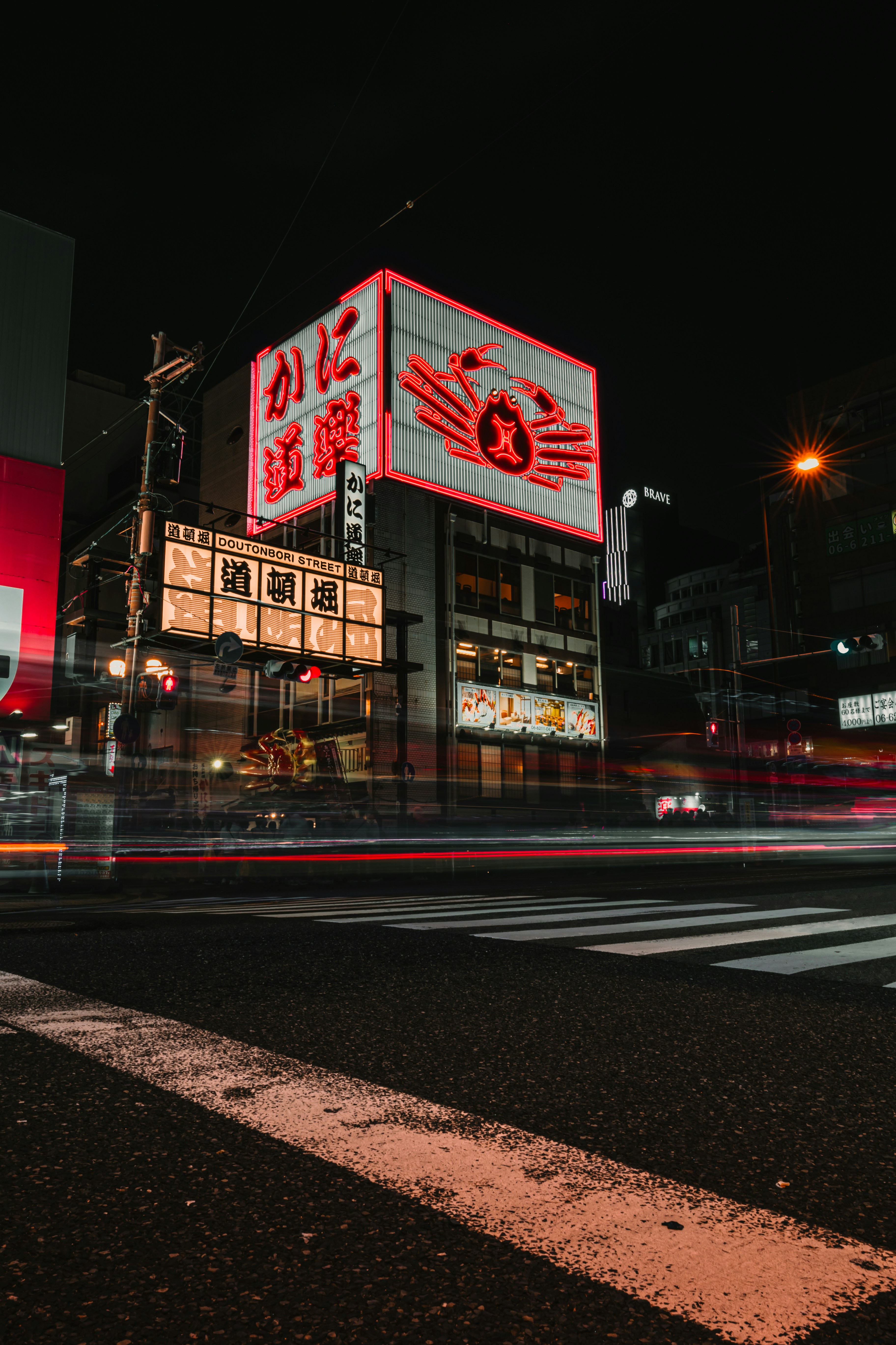 Neon signs illuminate a city street at night