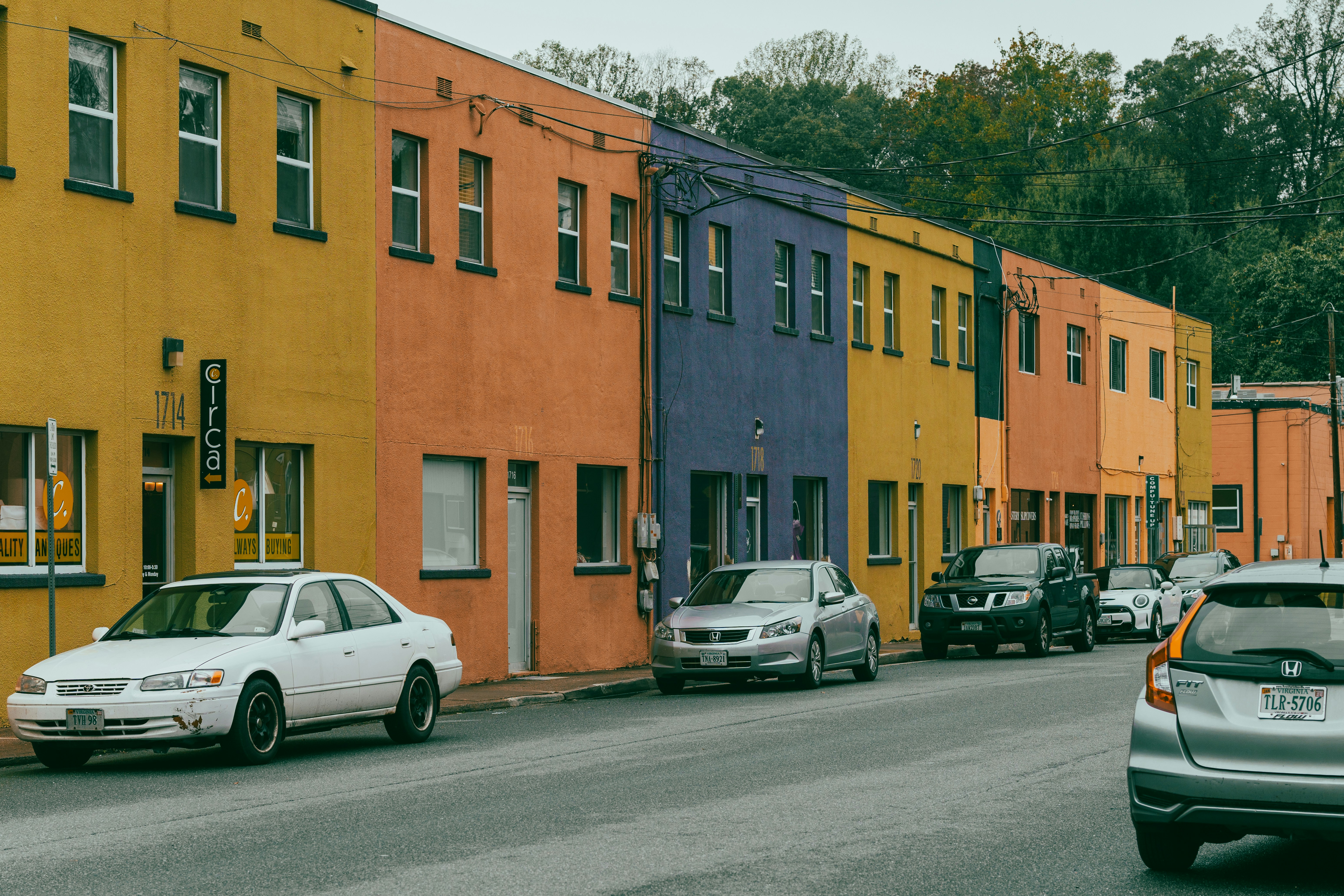 Colorful buildings on a street with parked cars.