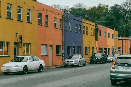 Colorful buildings line a street with parked cars