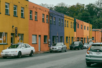 Colorful buildings line a street with parked cars