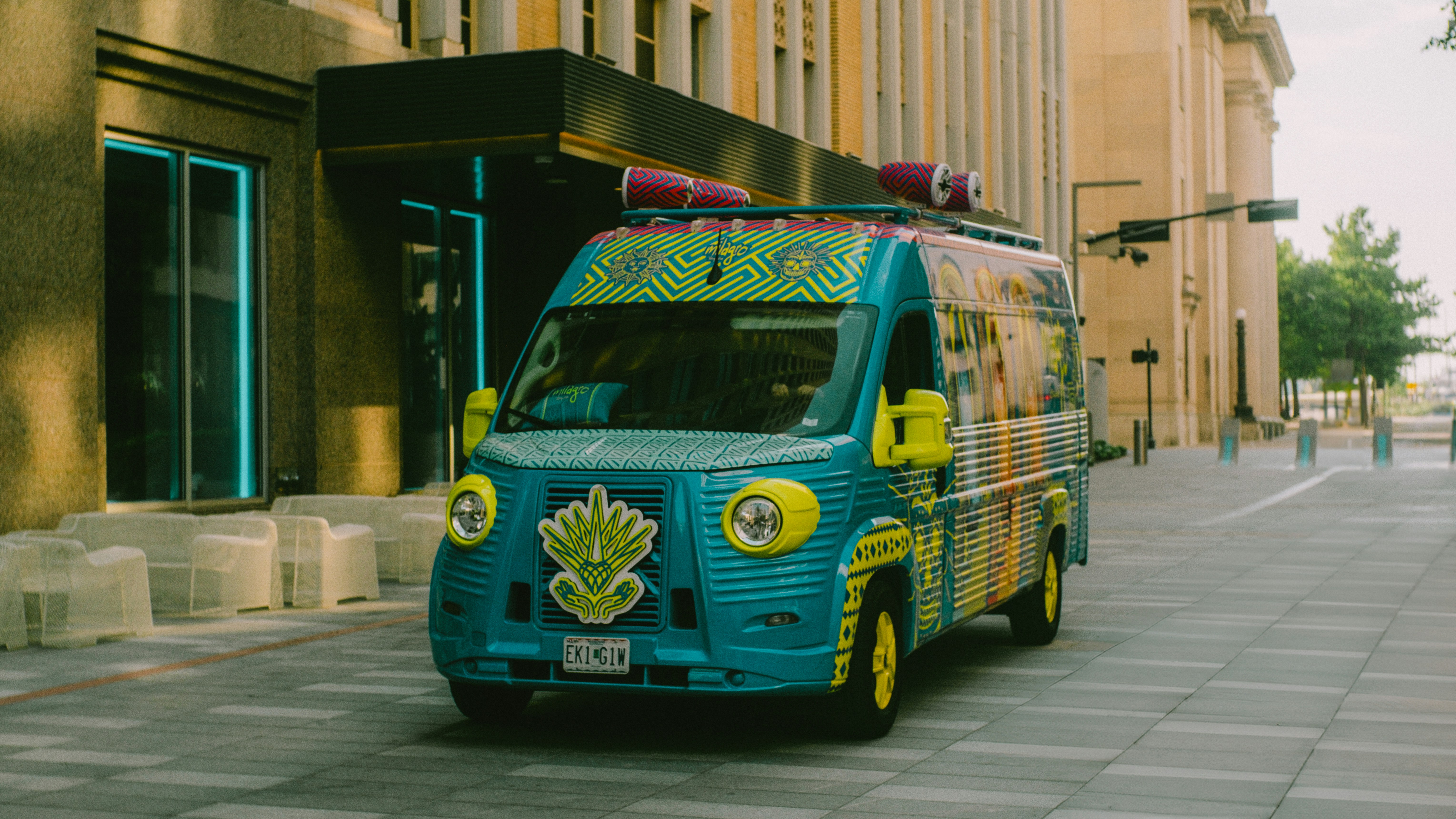 A colorful, decorated van drives down a city street.