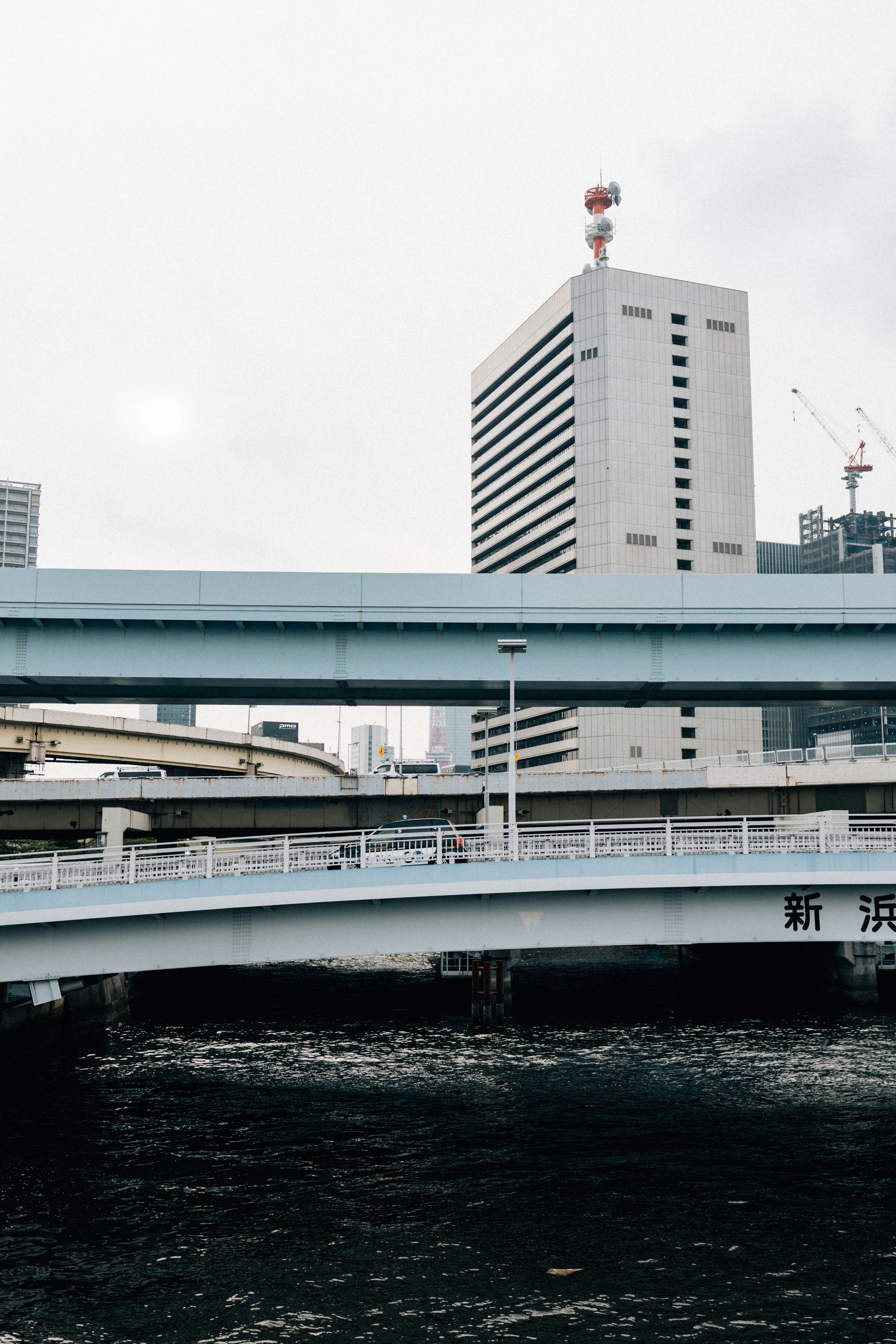 I ponti attraversano un fiume scuro con edifici moderni.