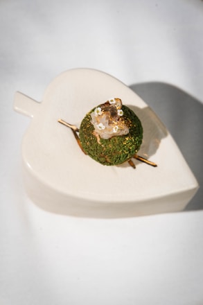 Green dessert with edible flowers on leaf plate