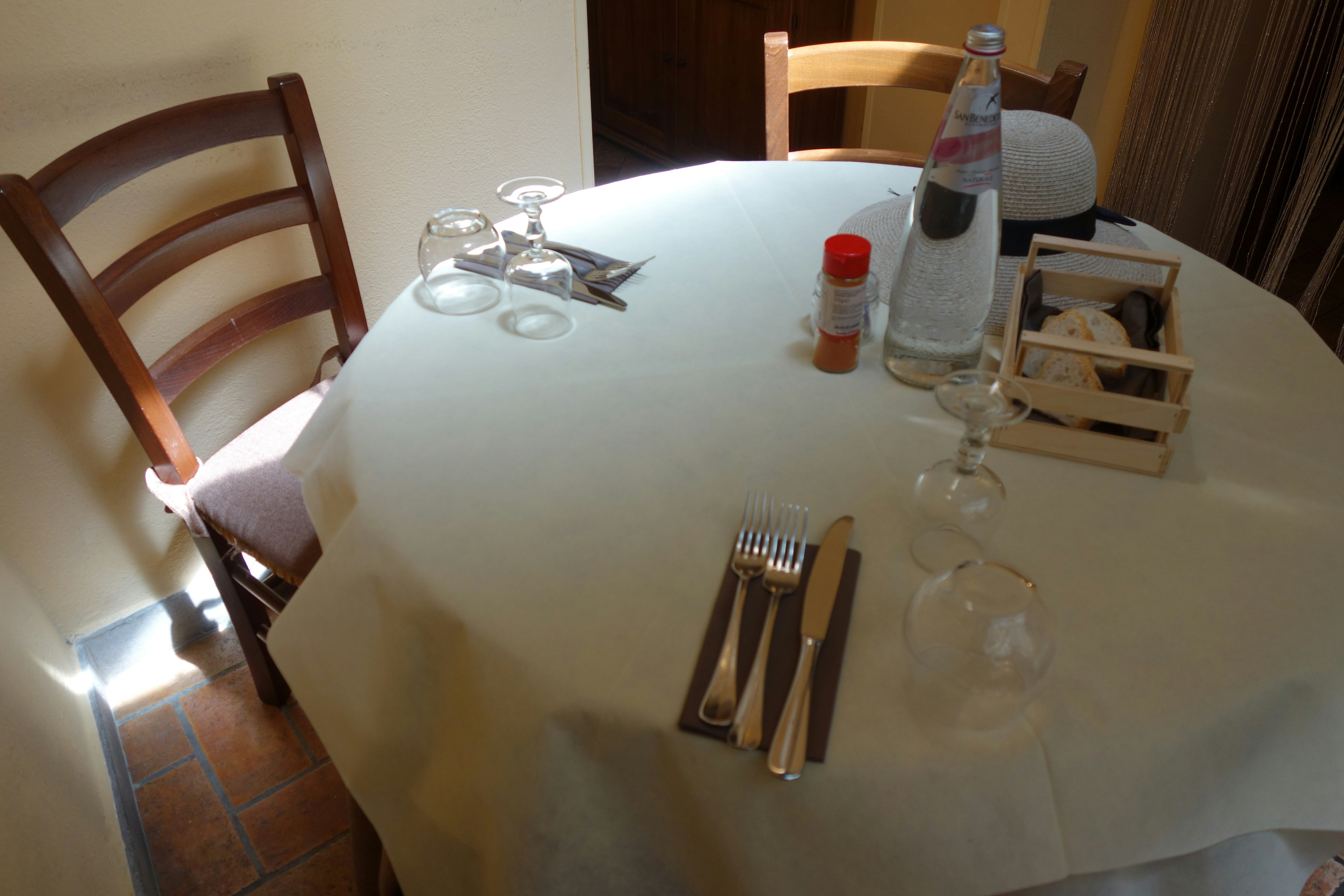 Table setting with chairs, water, and cutlery.