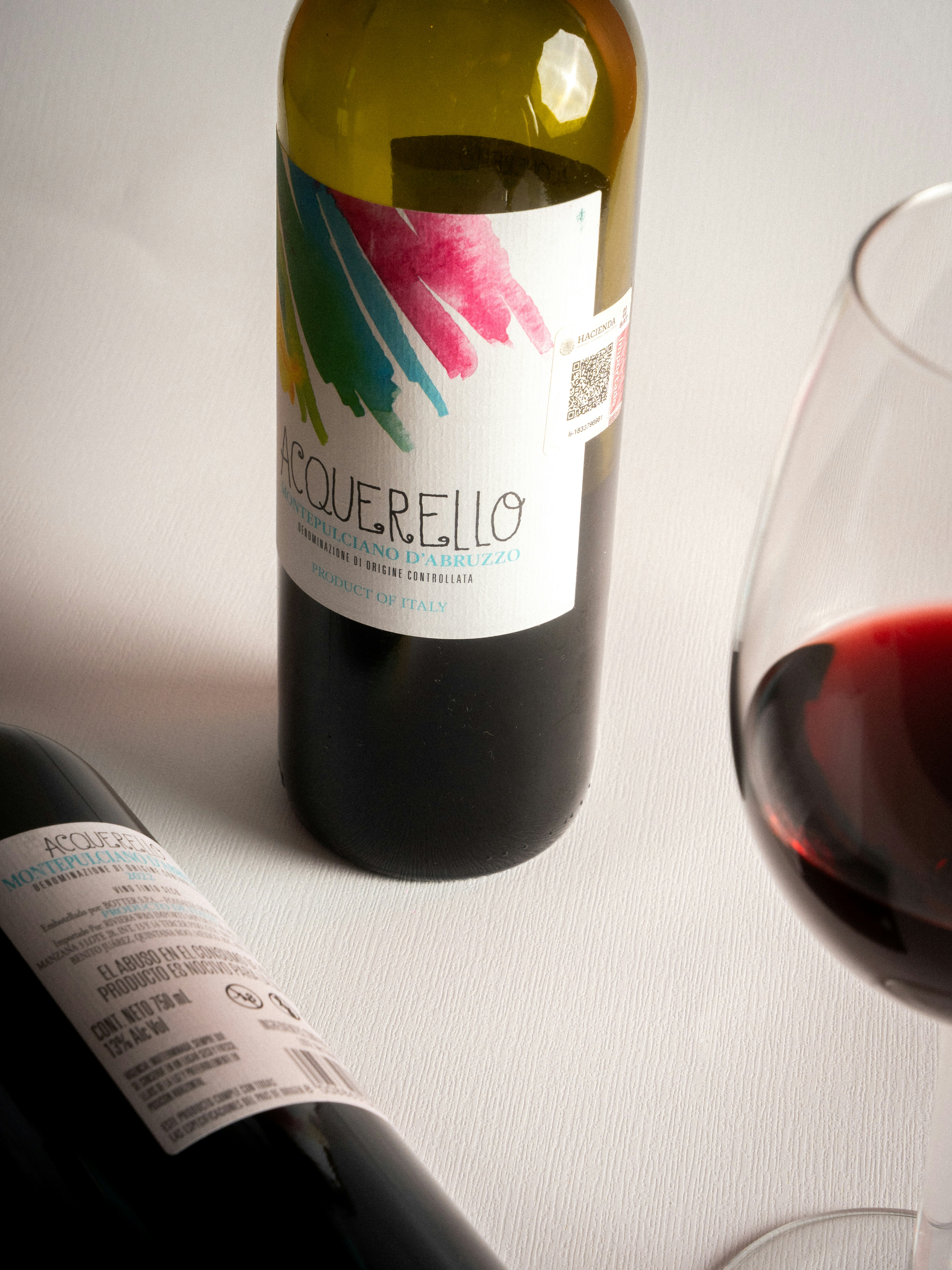 Dos botellas de vino tinto y una copa.