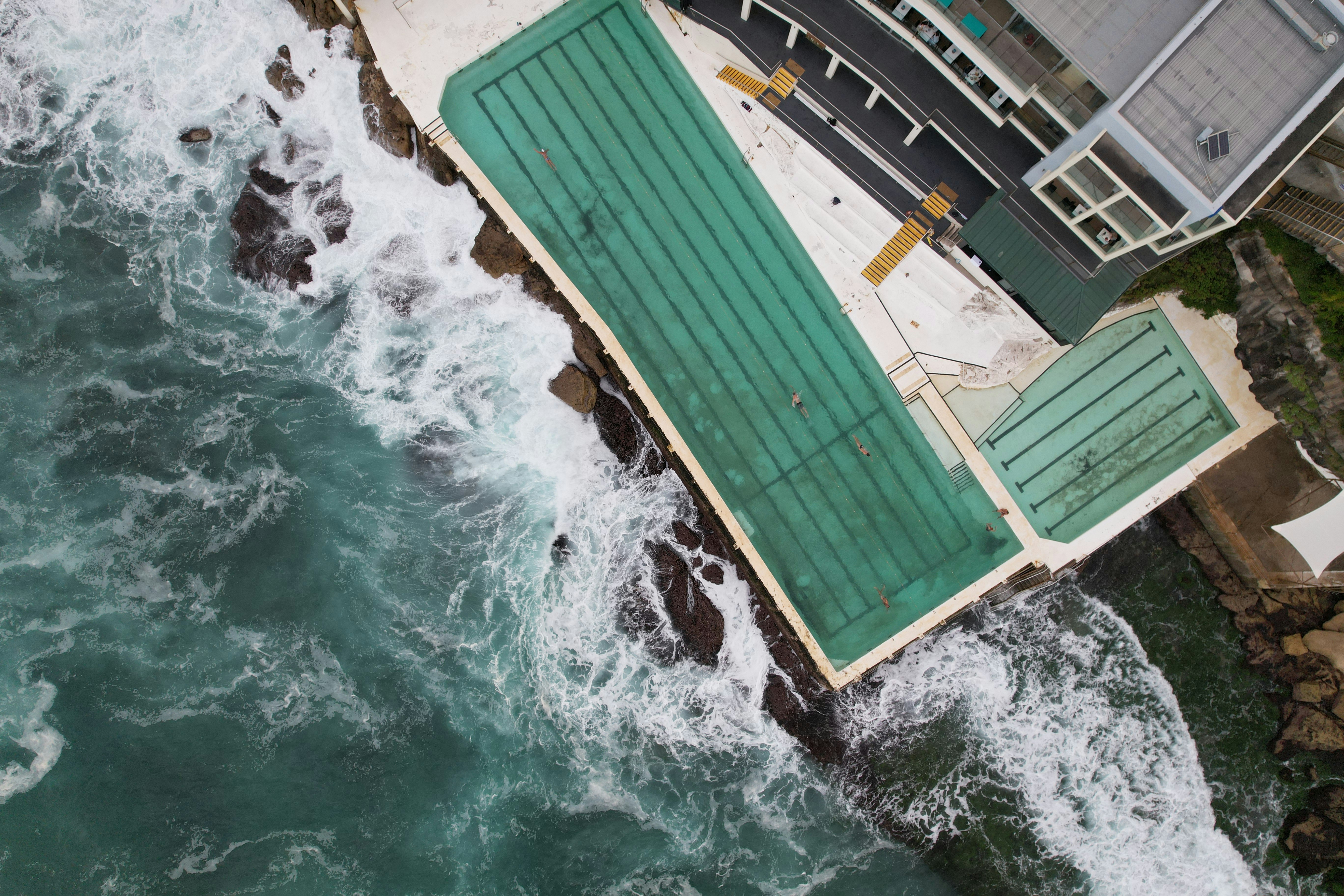 Ocean waves crashing against a coastal swimming pool.