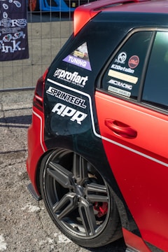 Red car with racing stickers and custom wheels