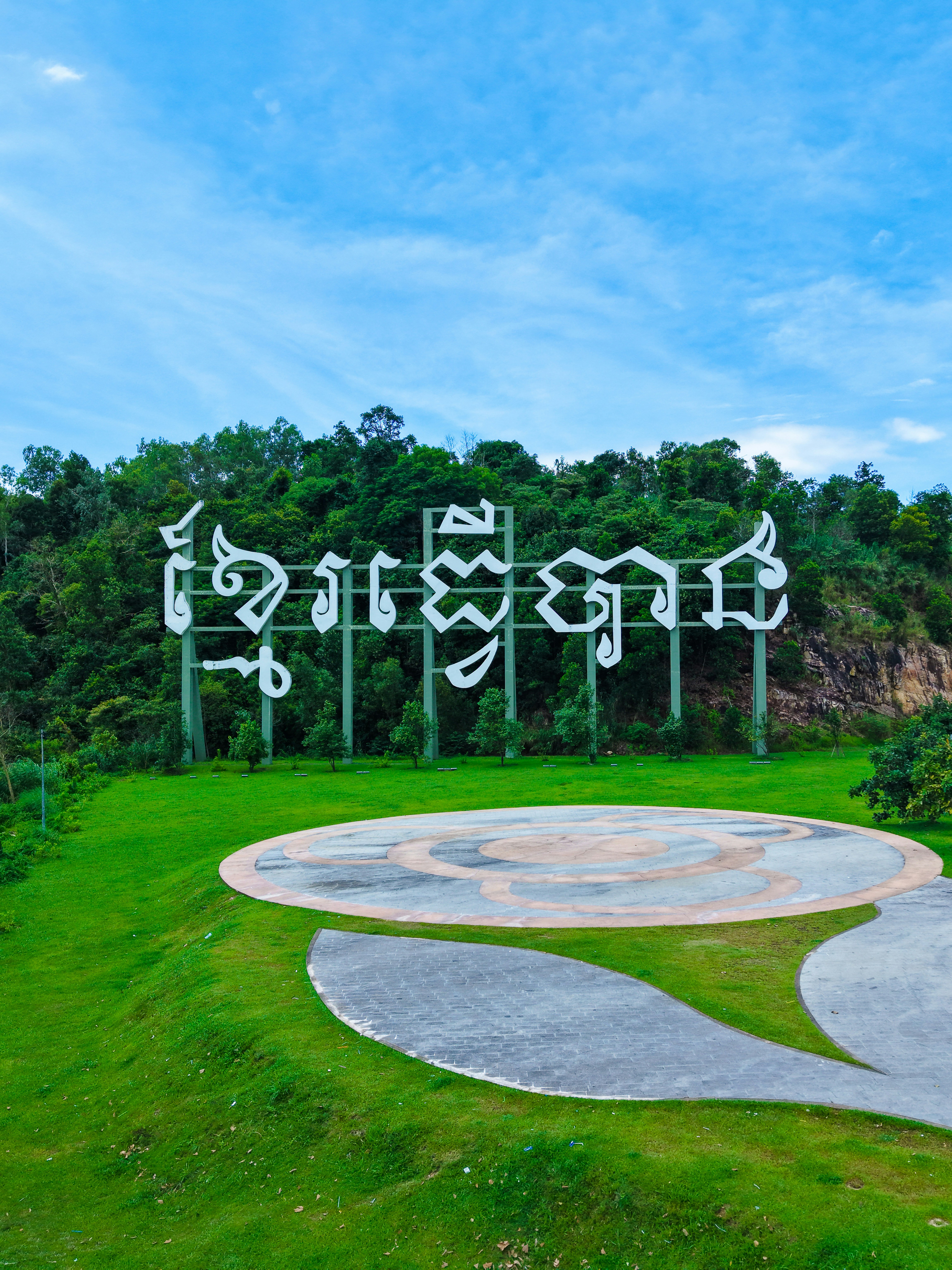 Large white lettering on a green hillside under sky.