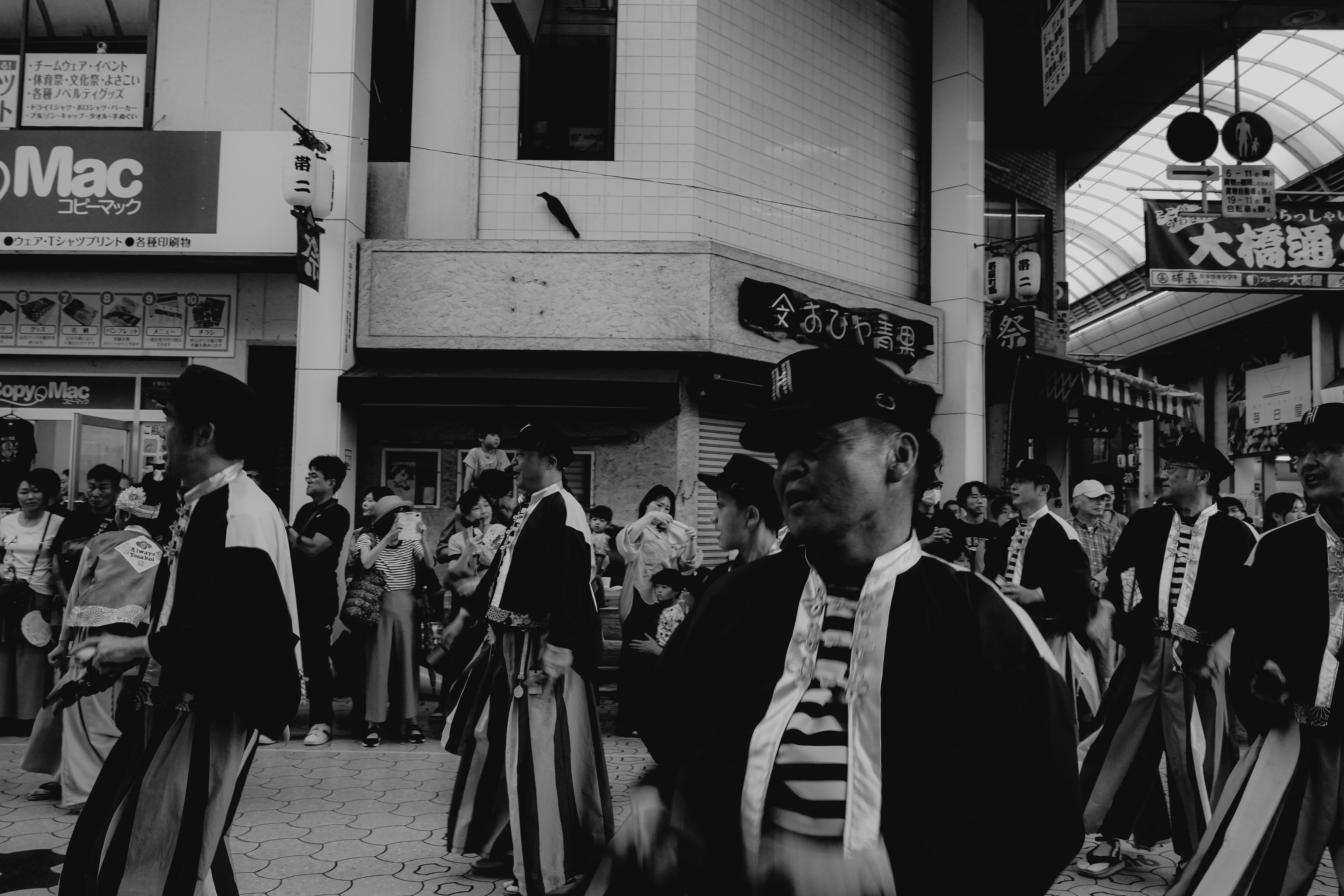 Men in traditional Japanese attire walking in a street festival.