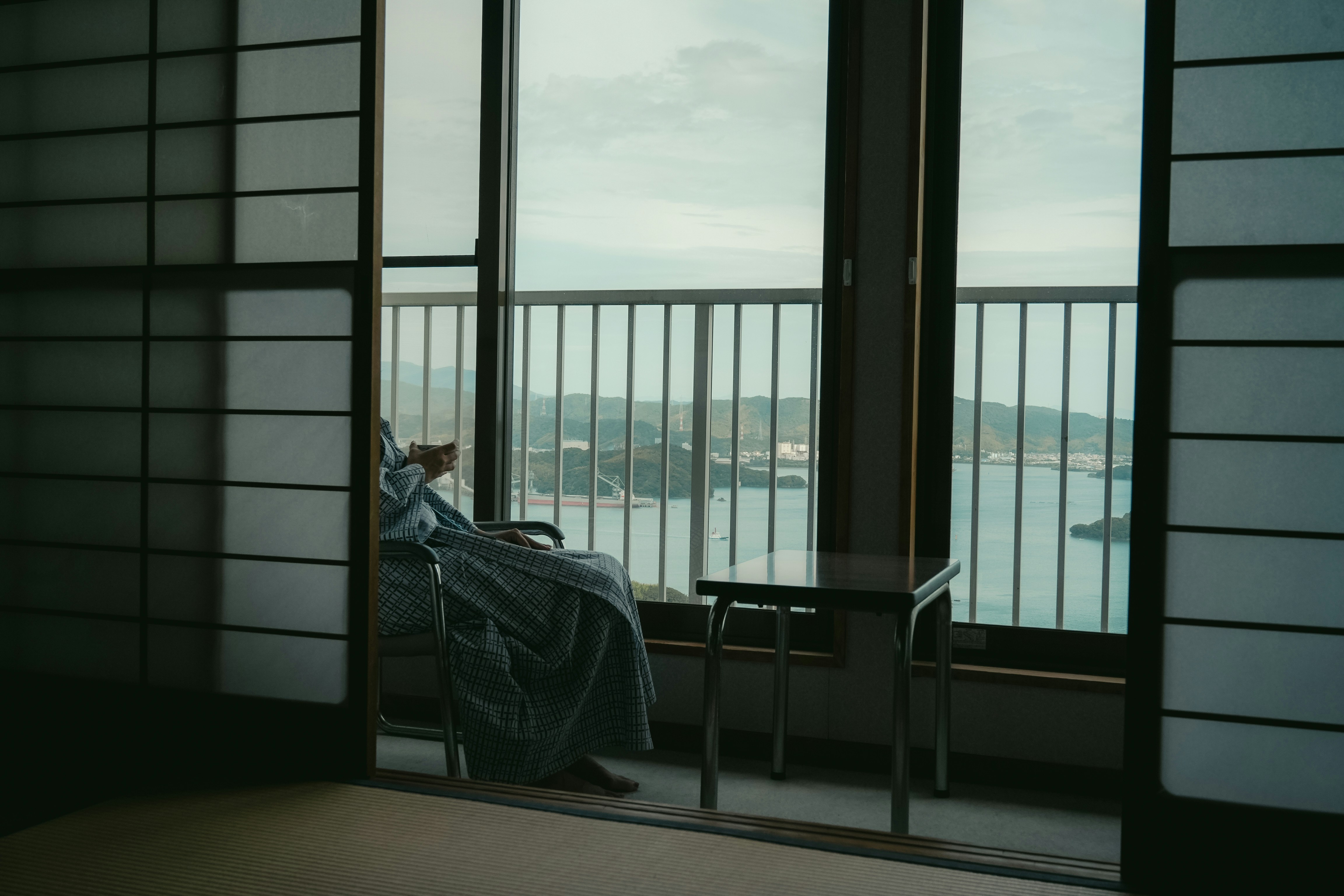 Person wrapped in blanket looking out window