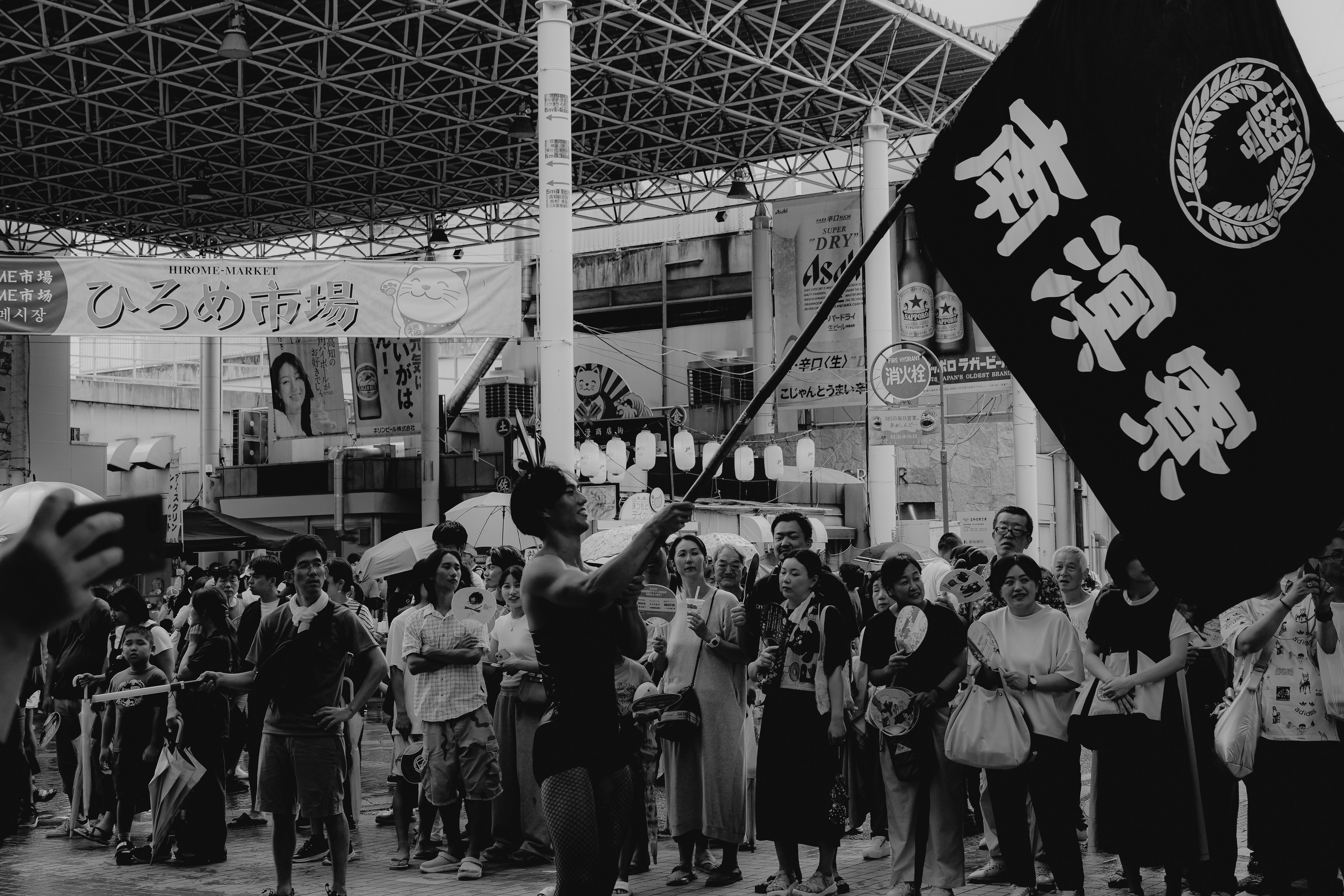 Man raises flag amidst crowd at market