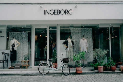 Bicycle parked outside a storefront with mannequins