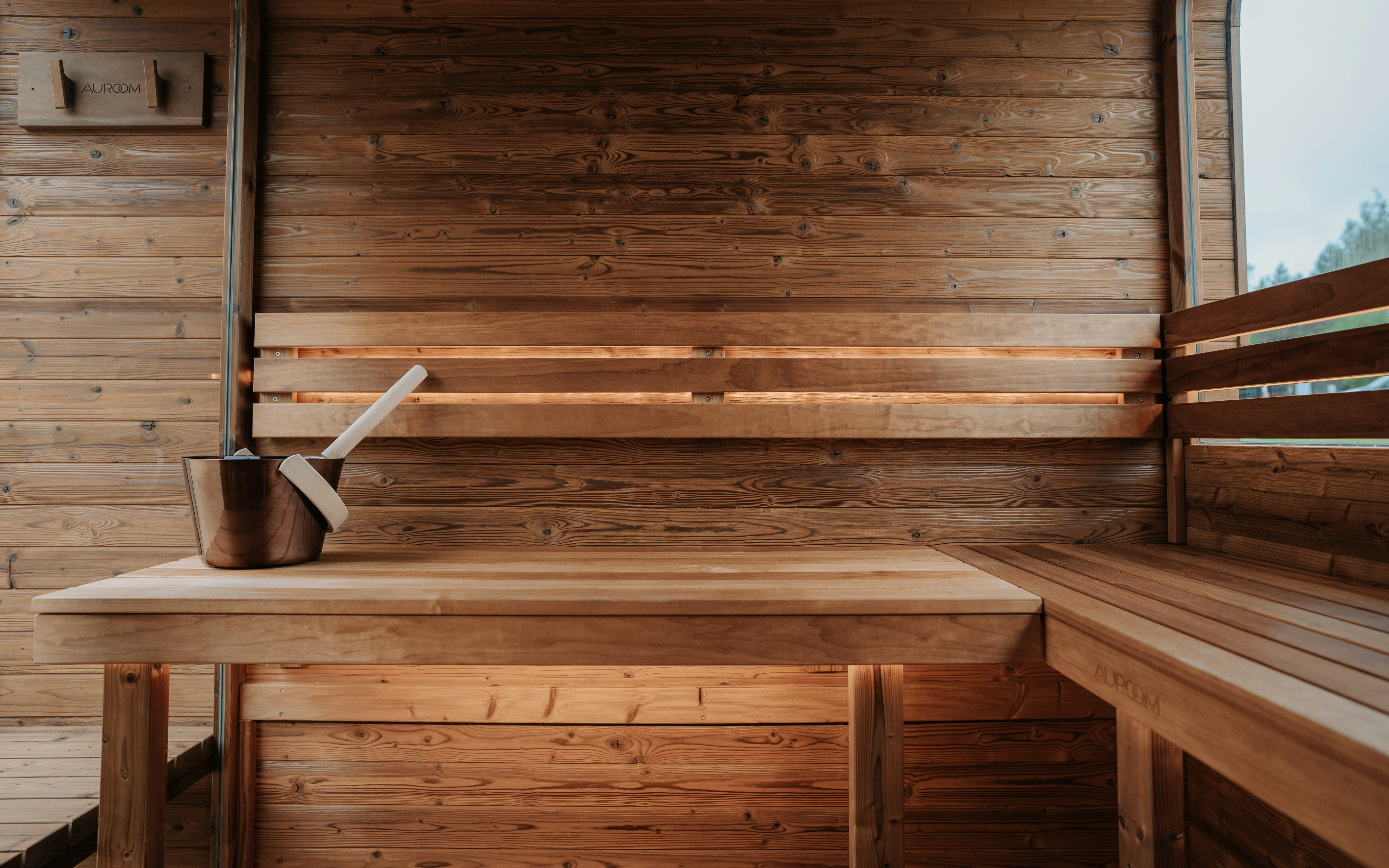 Wooden sauna interior with bucket and ladle.