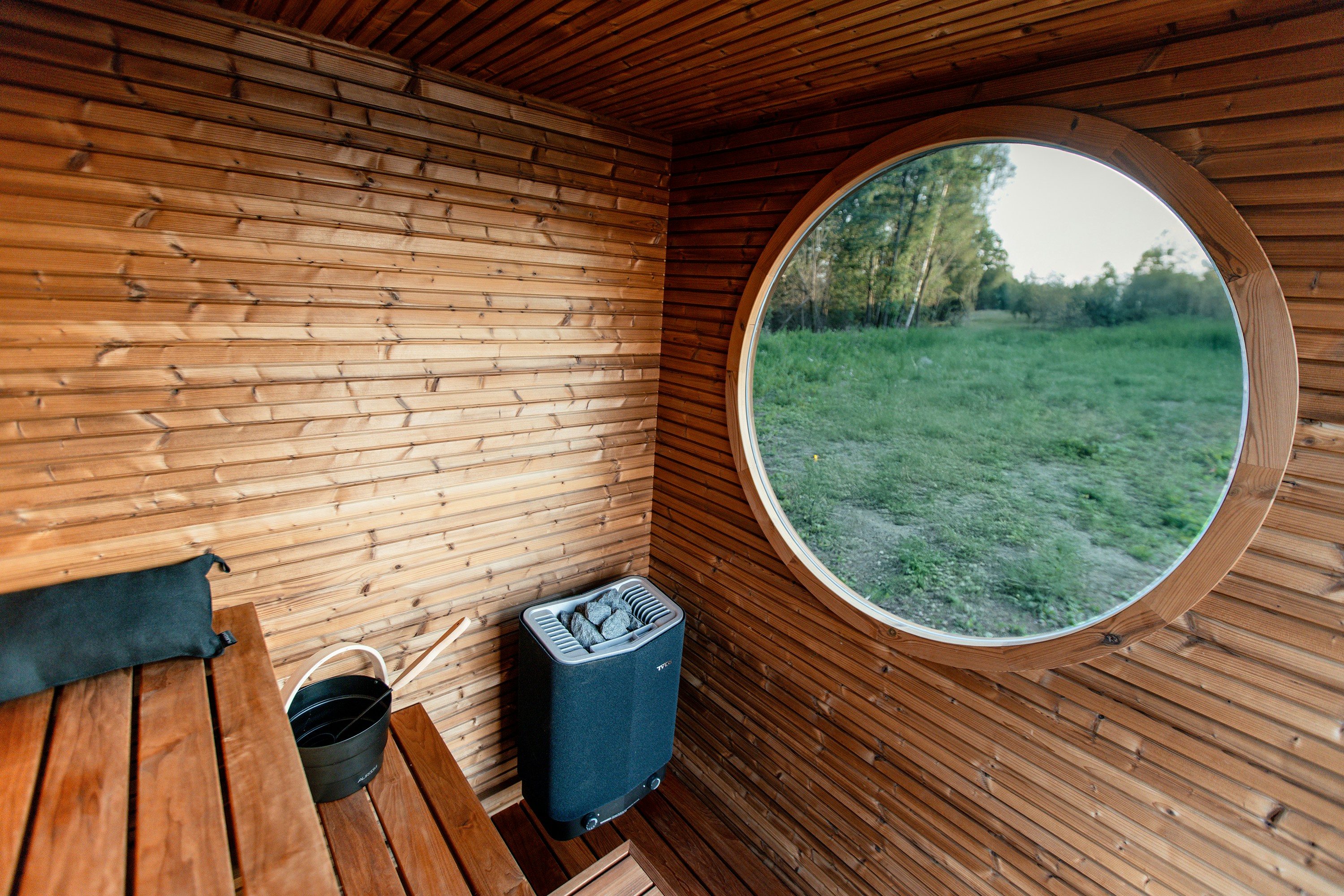 Wooden sauna with panoramic window overlooking nature