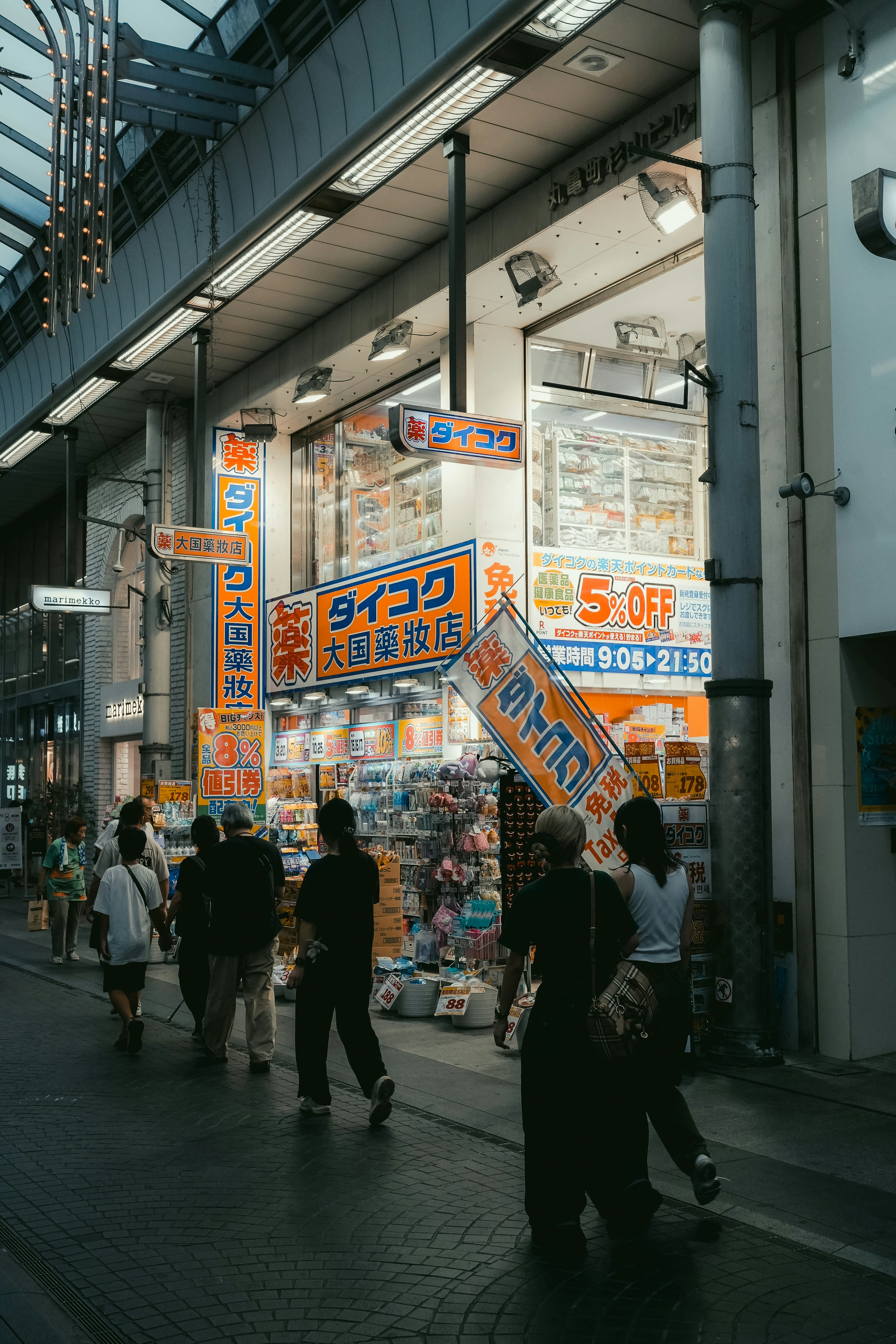 People walking down a street lined with shops.