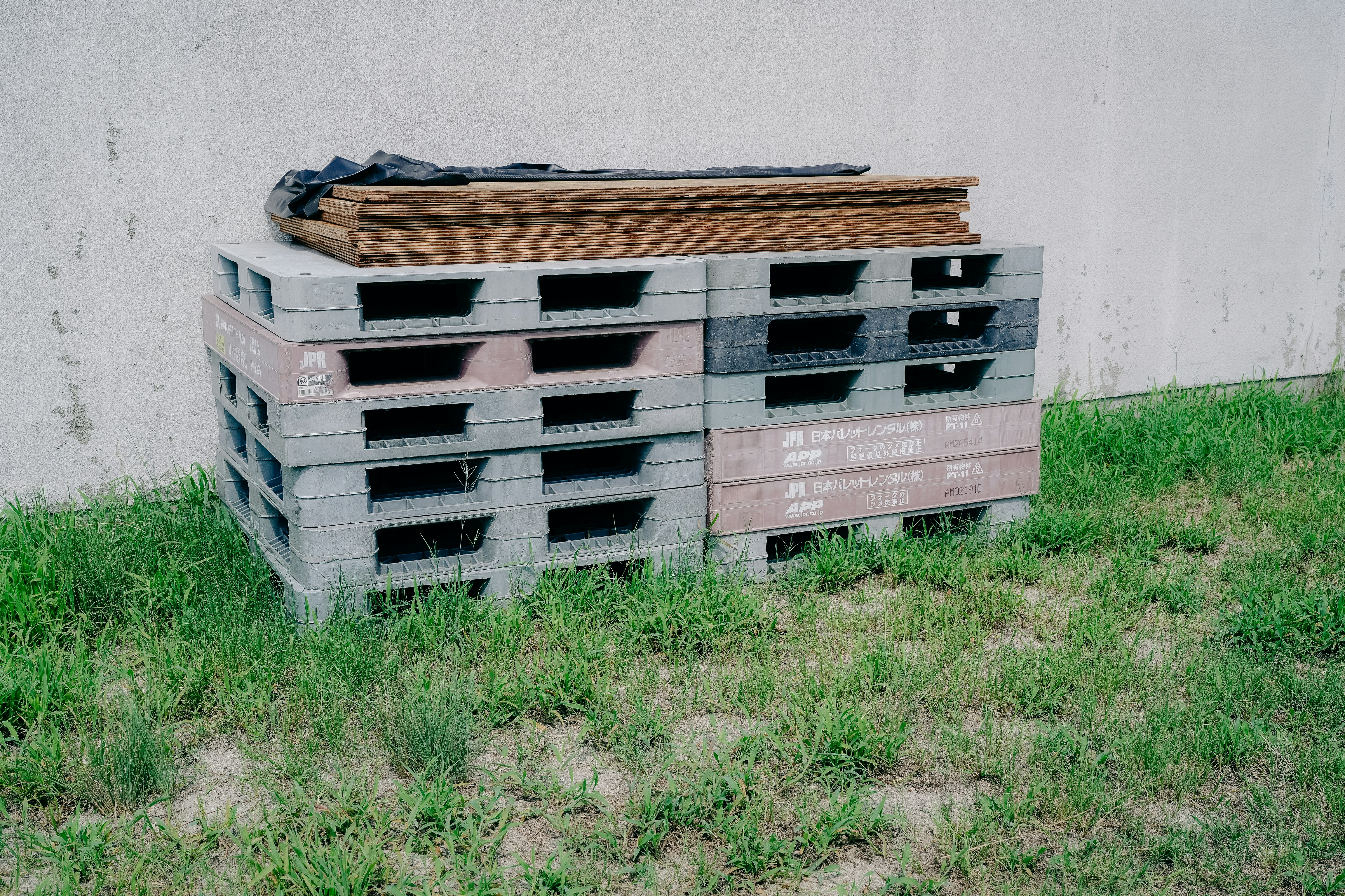 Gestapelte Kunststoffpaletten mit Holzbrettern