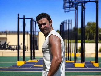 Man posing after a workout at an outdoor gym.