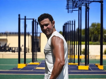 Man posing after a workout at an outdoor gym.