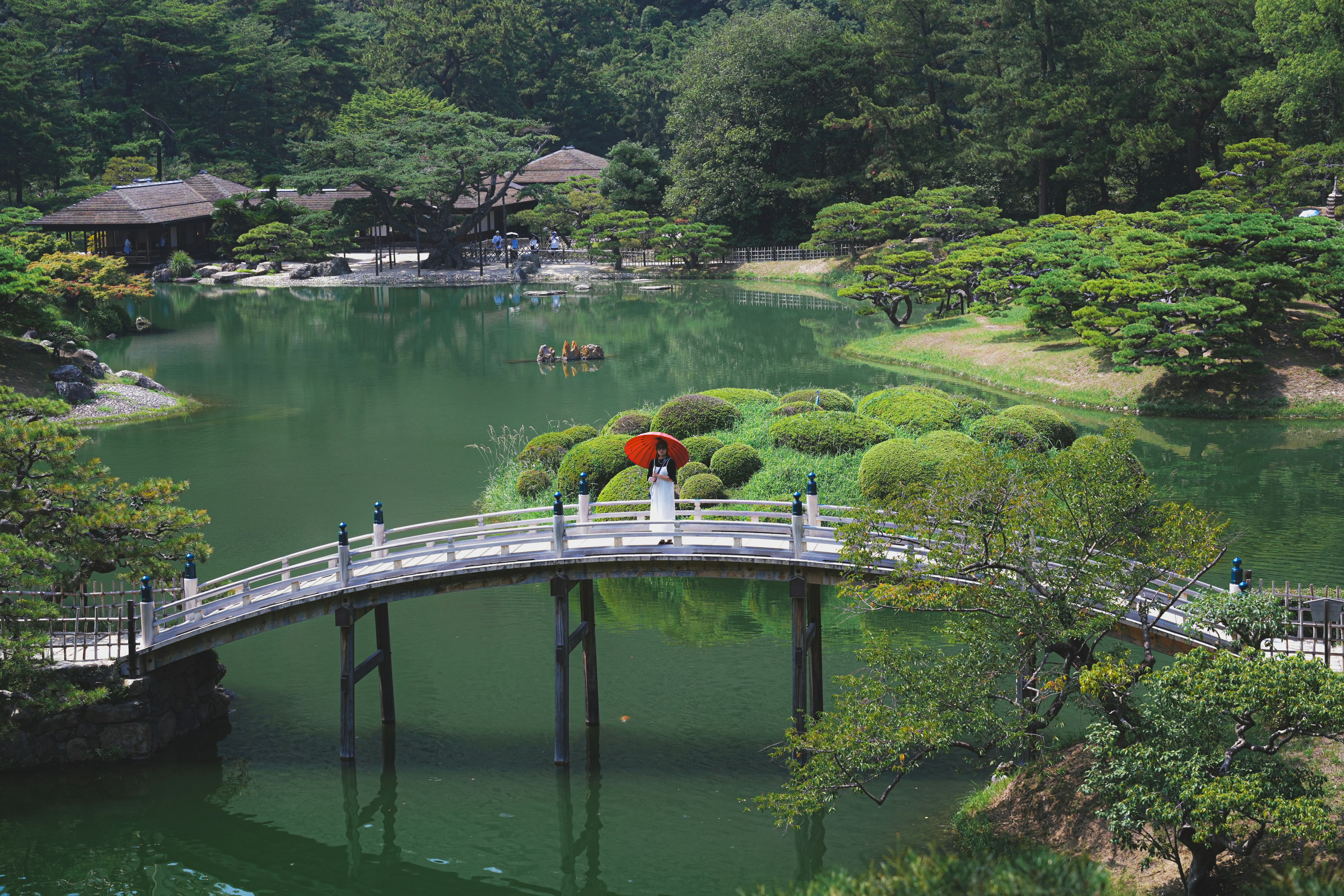 A japanese garden with a bridge over water.