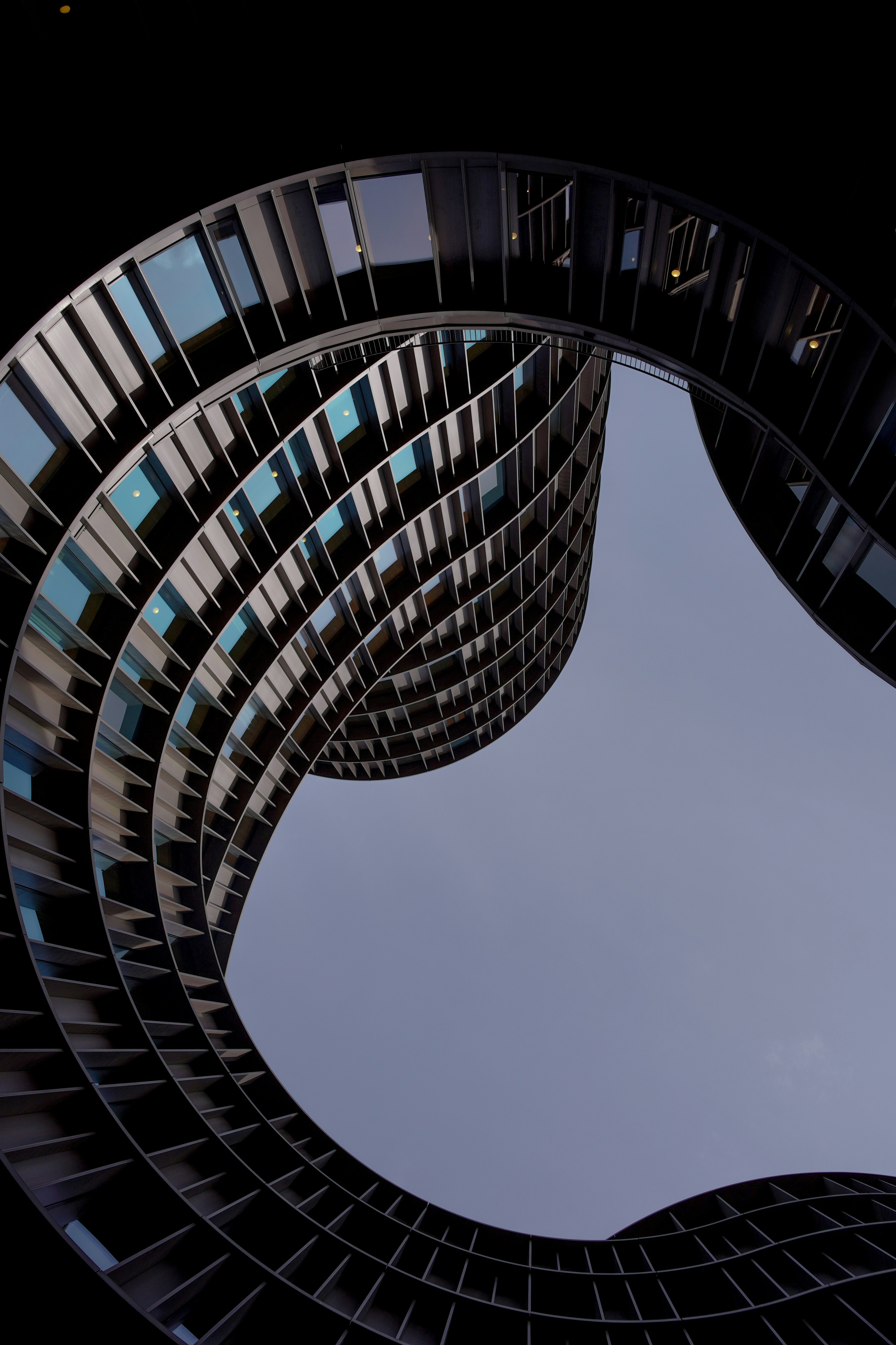 Geschwungene moderne Gebäudefassade vor klarem Himmel