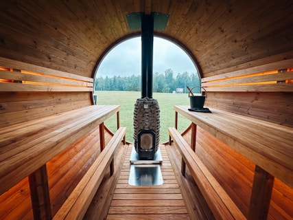 Interior of a wooden barrel sauna with a stove.