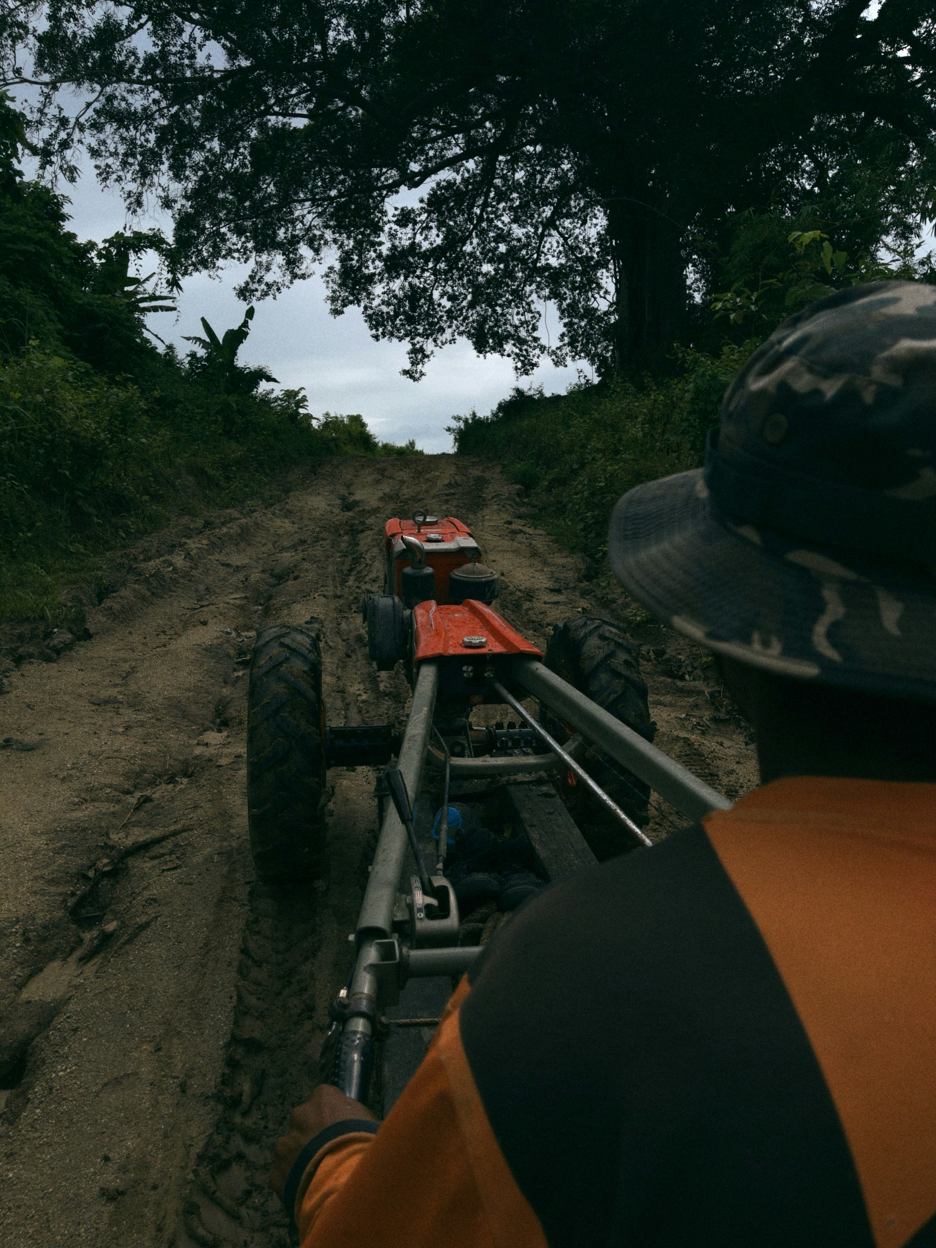 Pessoa empurrando um leme em uma estrada rural lamacenta
