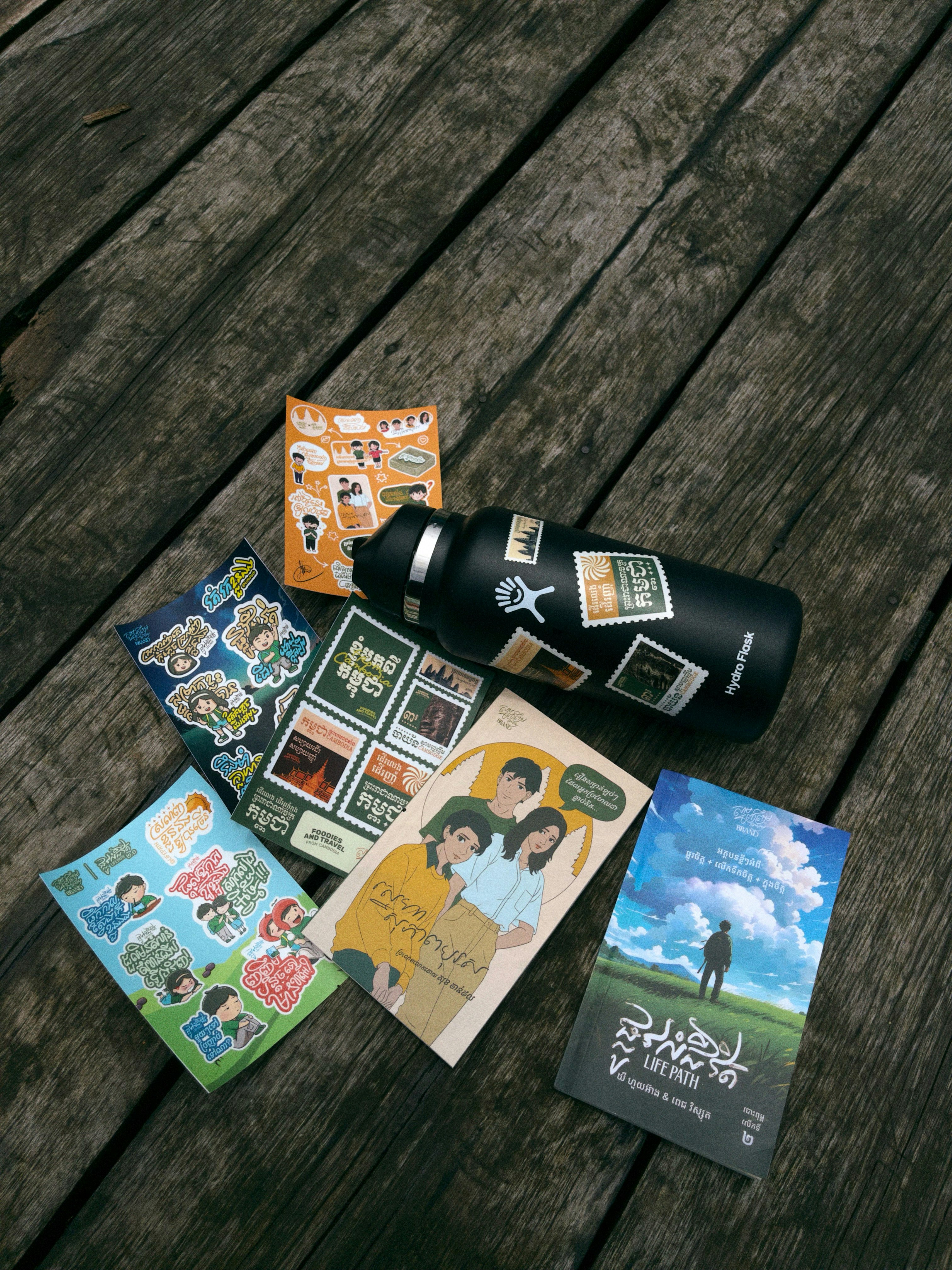 Water bottle with stickers and books on wood