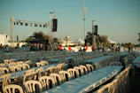 Rows of empty tables and chairs at an outdoor event.