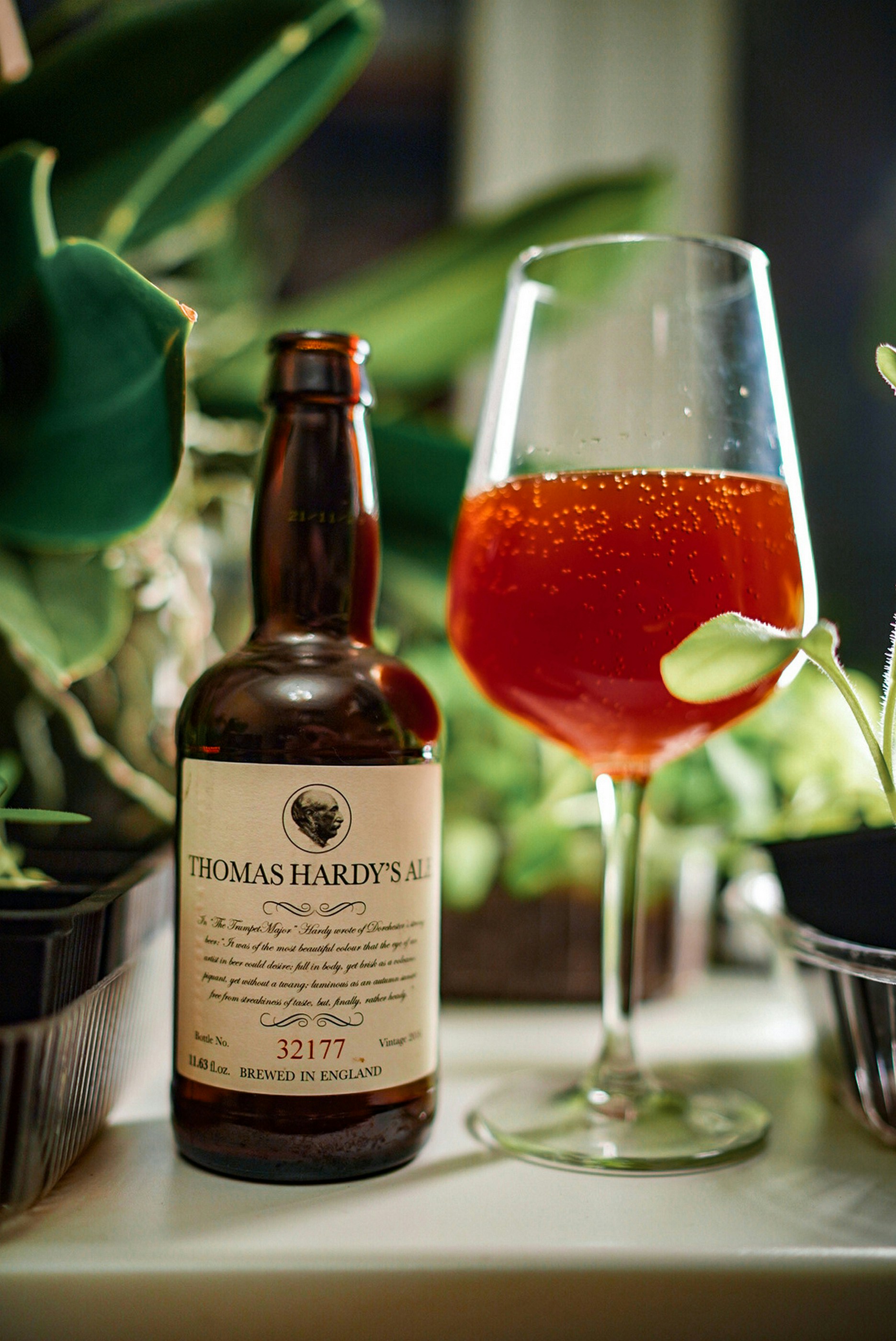Bottle of ale next to a glass of amber liquid.