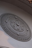 Ornate circular relief carving on a white wall.