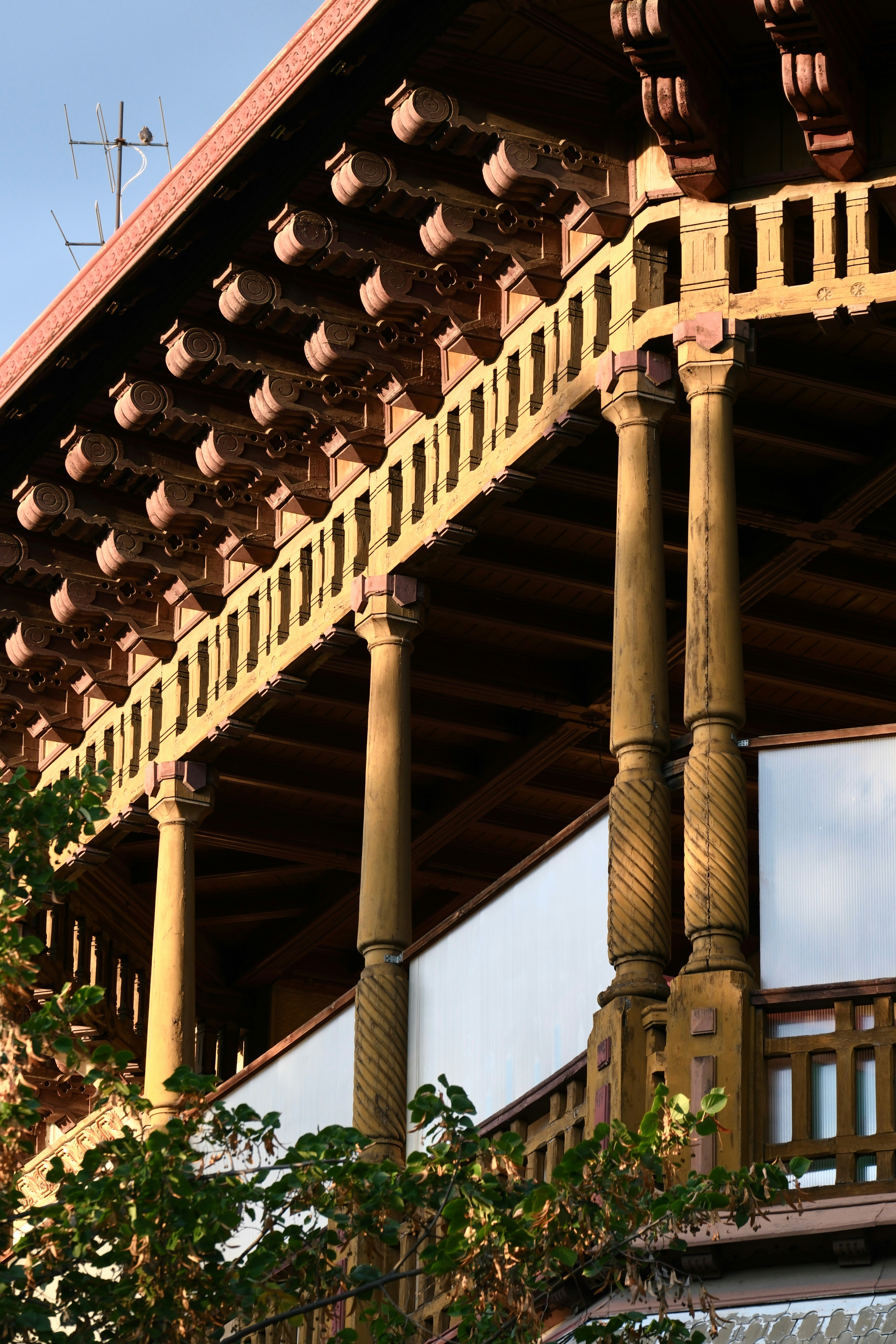 Balcón de madera ornamentado con tallas y columnas detalladas.