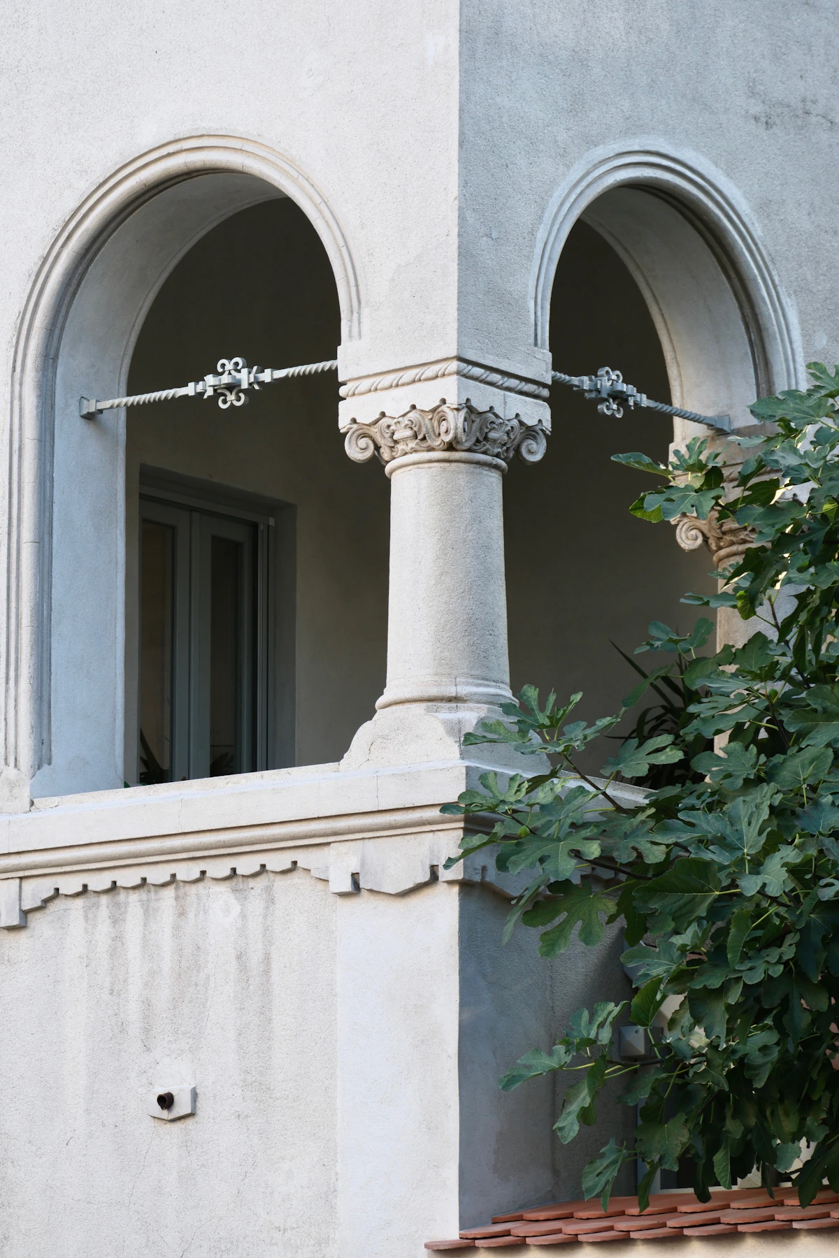 Mediterranean arched window framing lush foliage