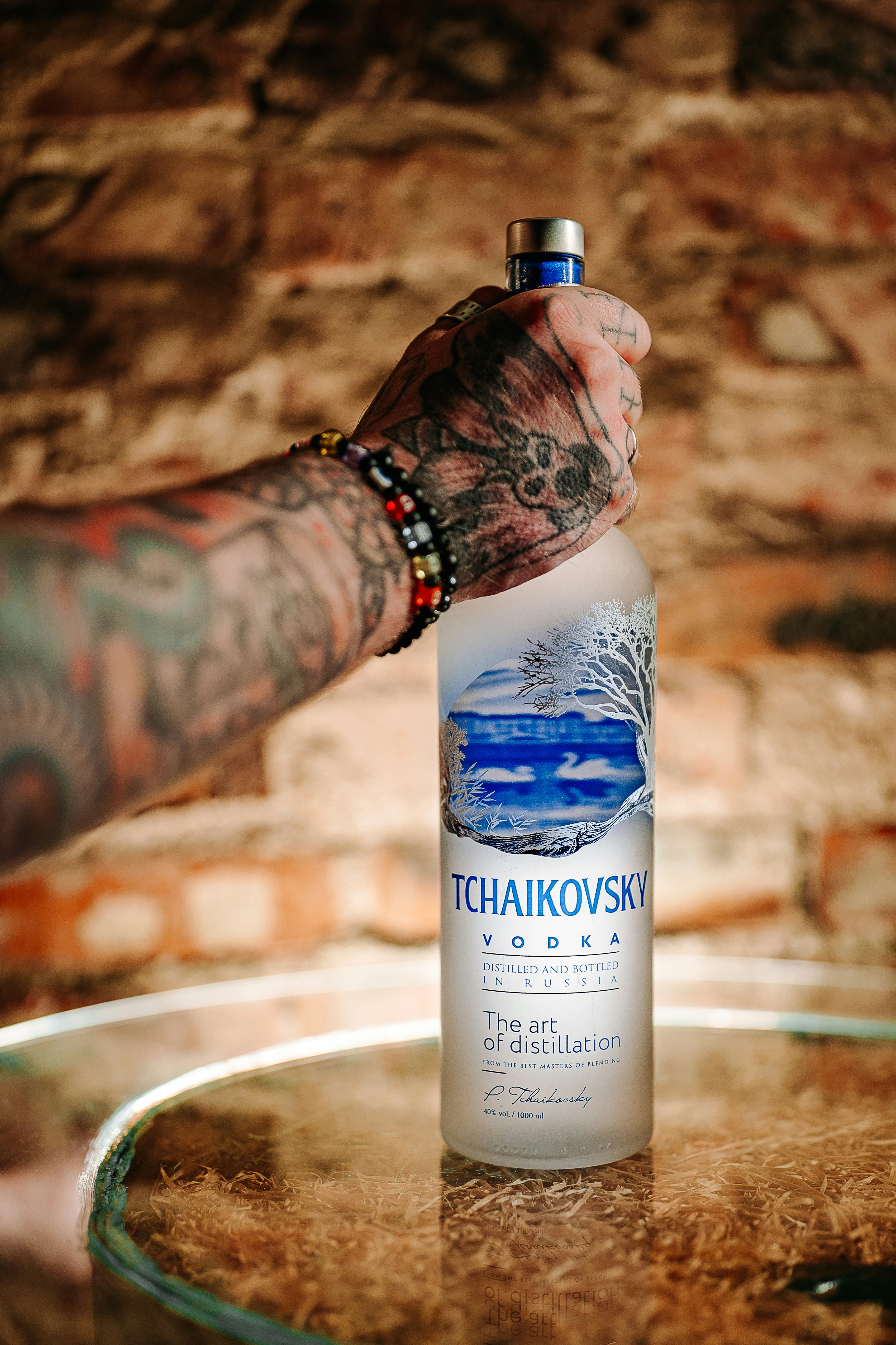 Tchaikovsky vodka bottle held by tattooed hand