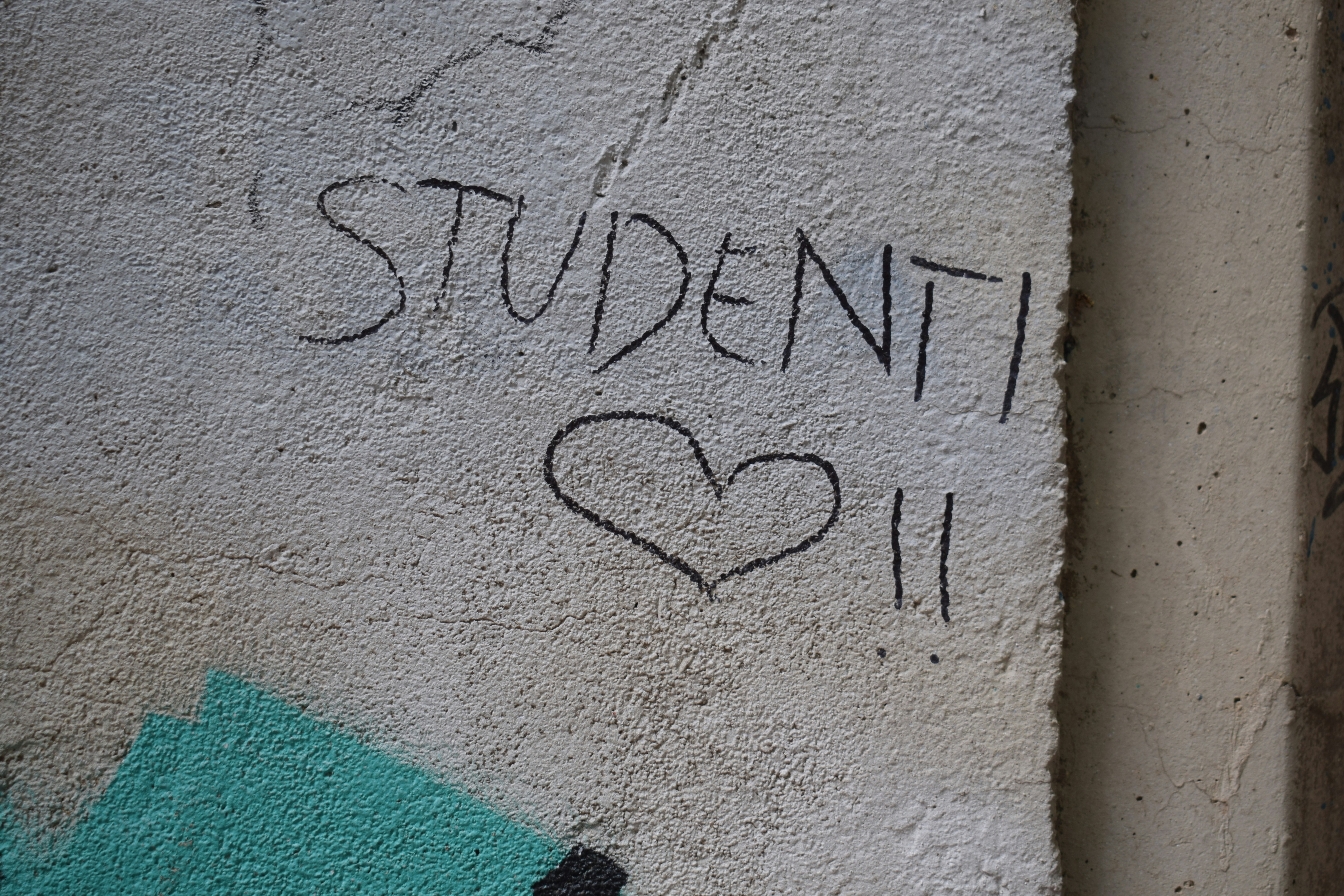 Graffiti on wall reads 'studenti' with a heart.
